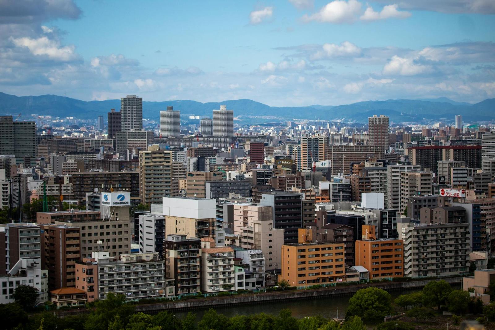 Dense mid-rise city skyline stretching toward distant mountains