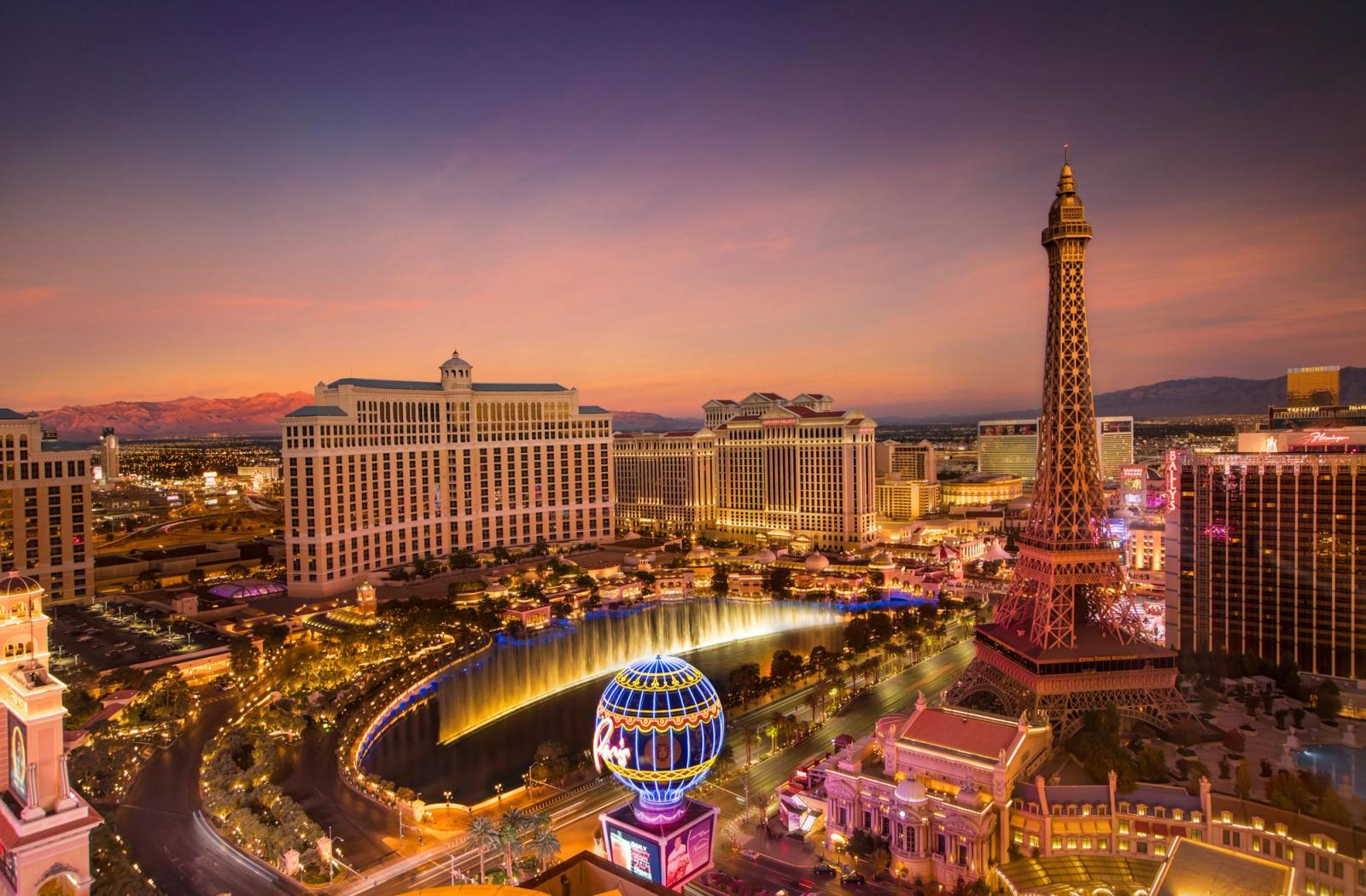 Stunning aerial view of Las Vegas skyline at sunset, featuring the Eiffel Tower and Bellagio fountains