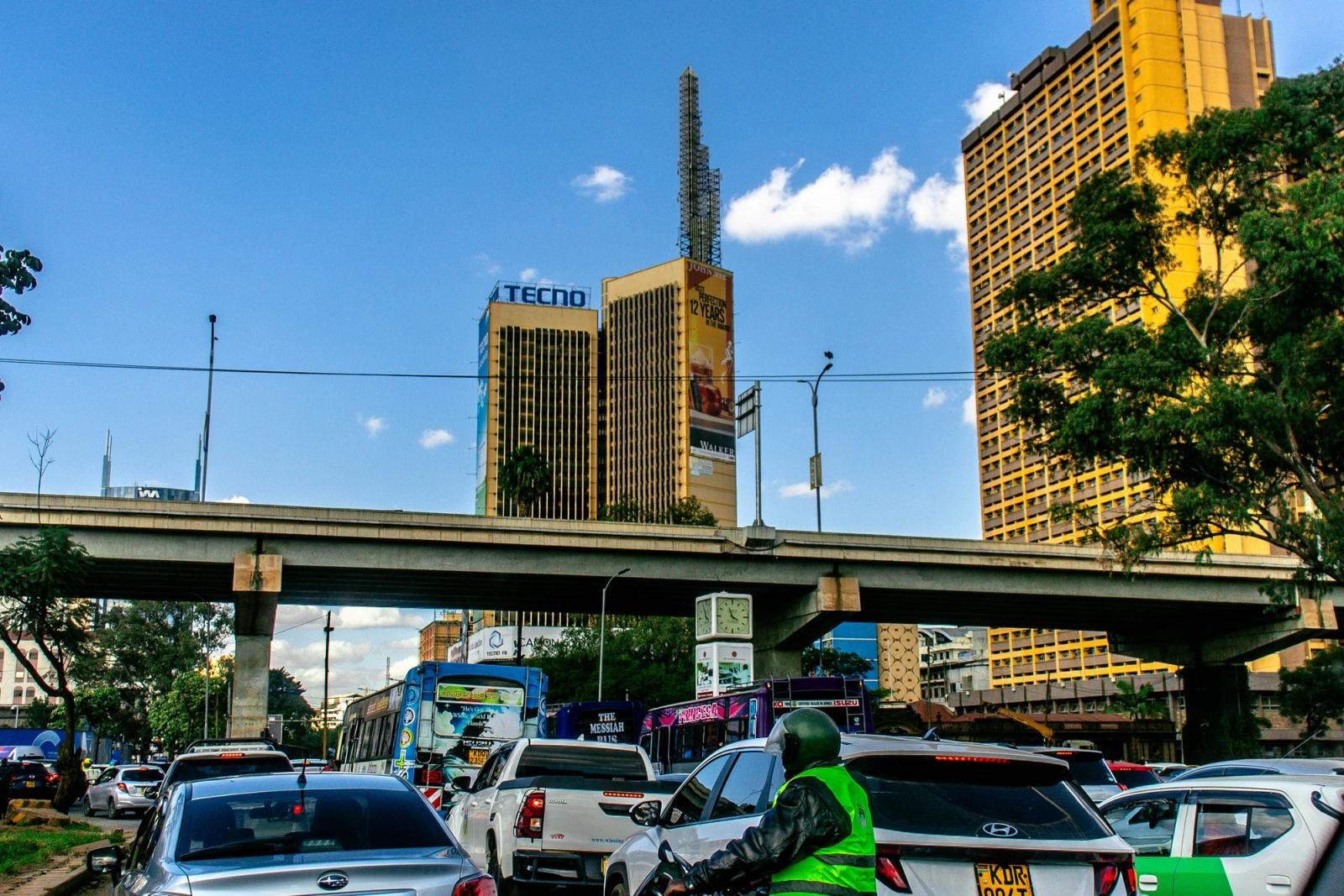 Street scene with traffic and tall buildings in Nairobi, Kenya on a clear day