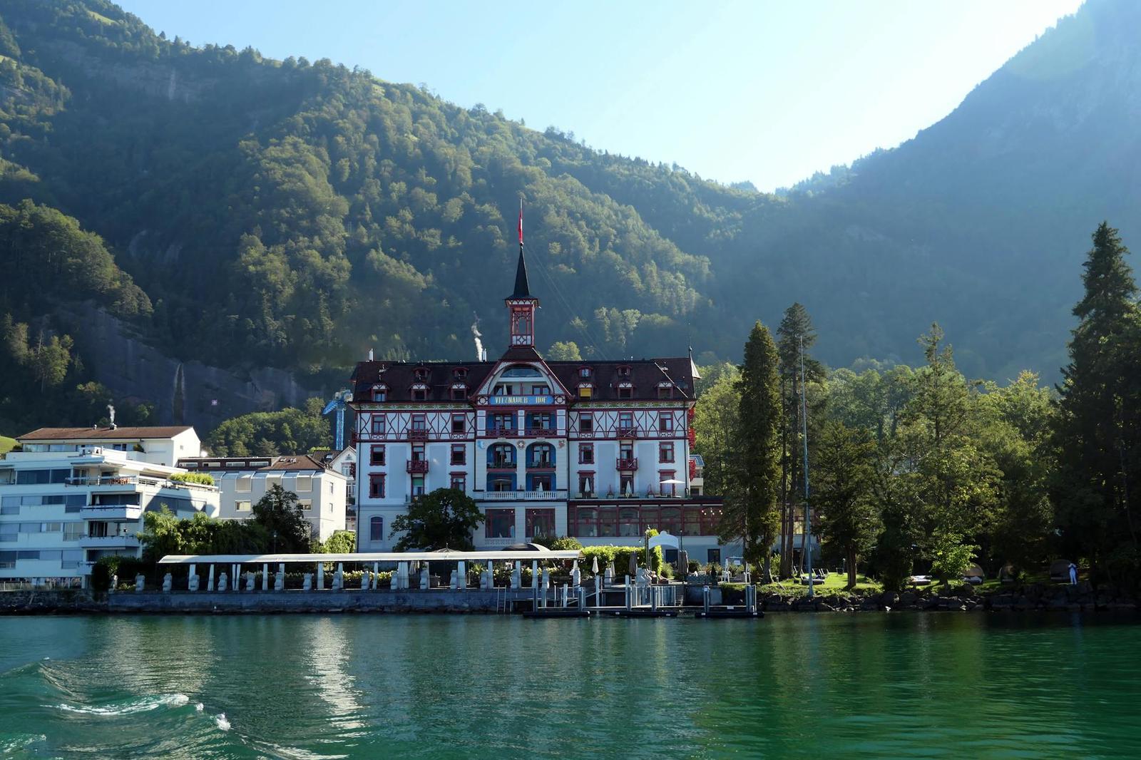 Charming hotel by Lake Lucerne in Vitznau, bathed in sunlight with mountain backdrop