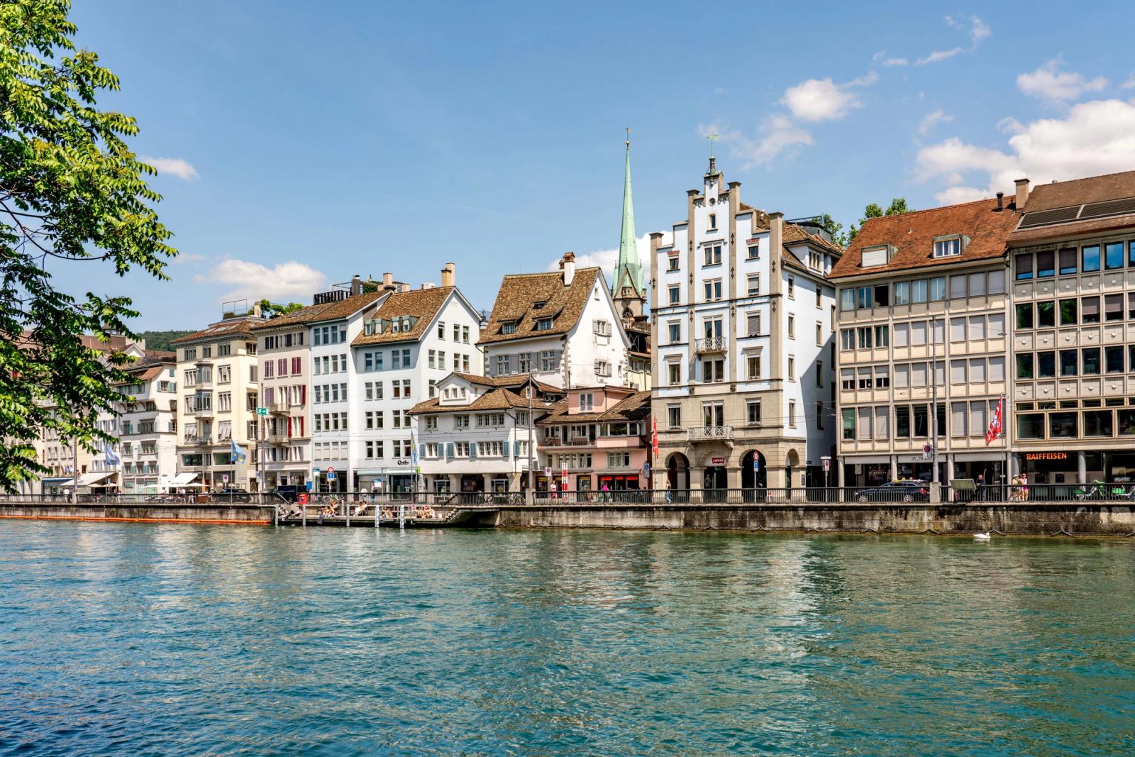 Scenic view of Zurich's historic waterfront buildings along the Limmat River on a sunny day