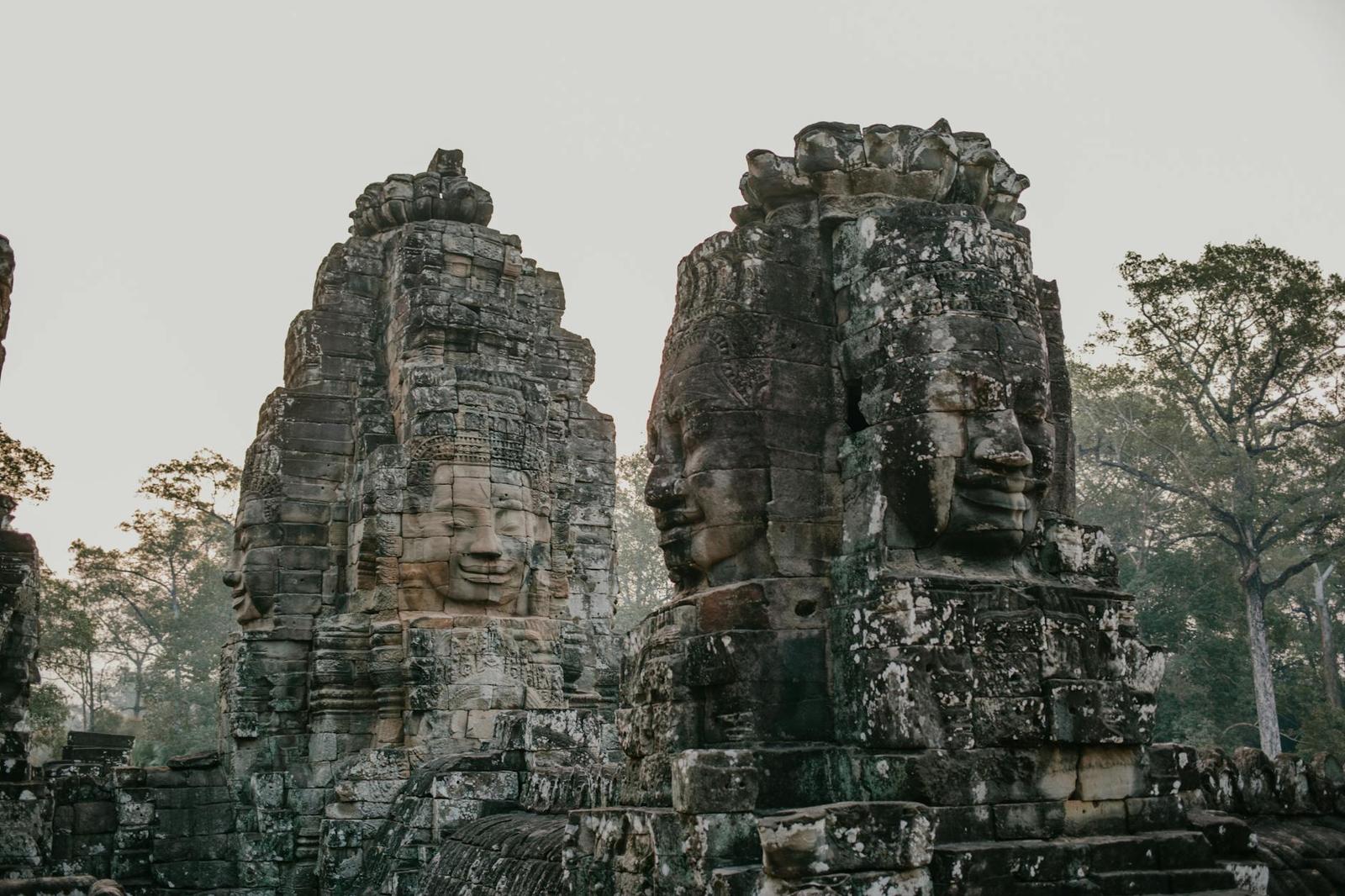 Close-up of weathered stone faces carved into the towers of the Bayon temple