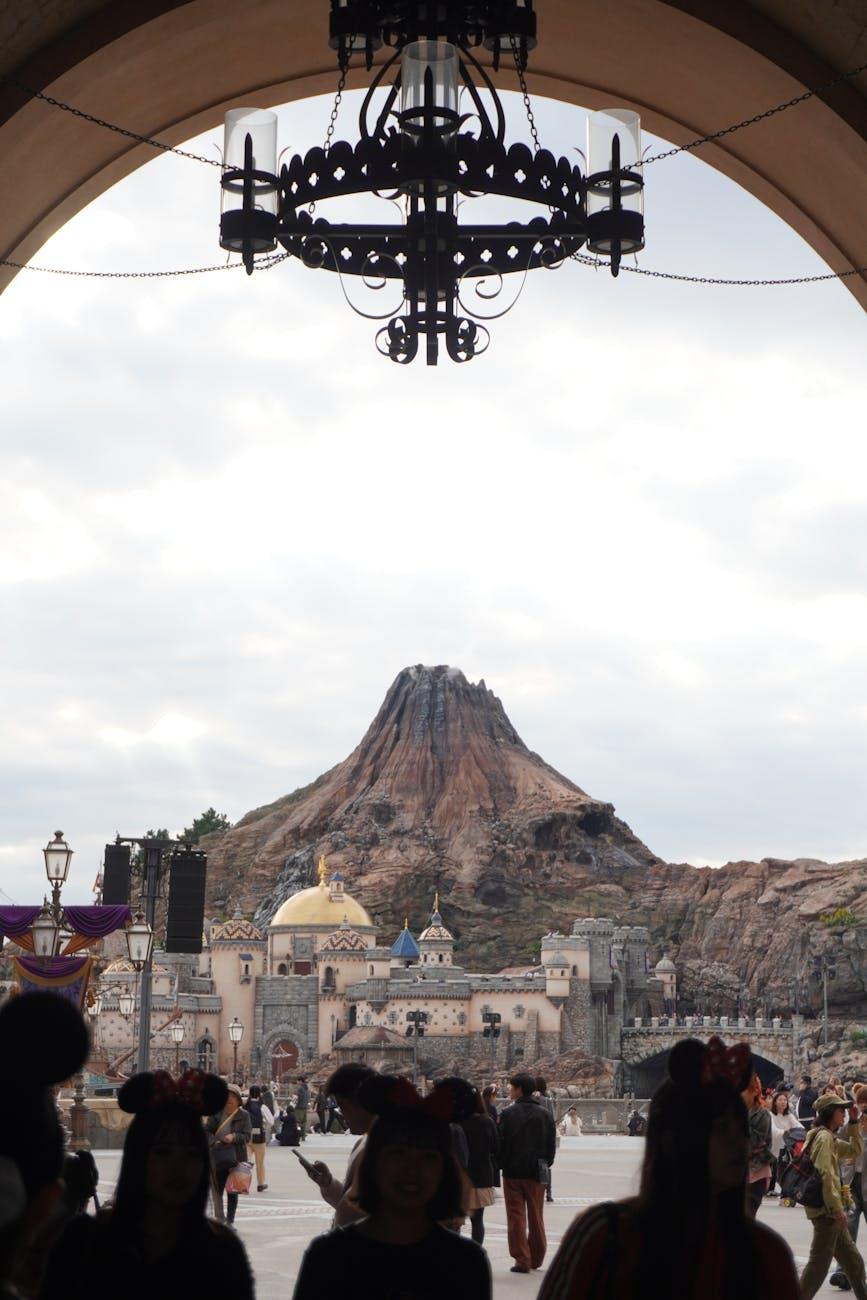 Silhouettes and enchanting view of Mount Prometheus at Tokyo DisneySea under an archway