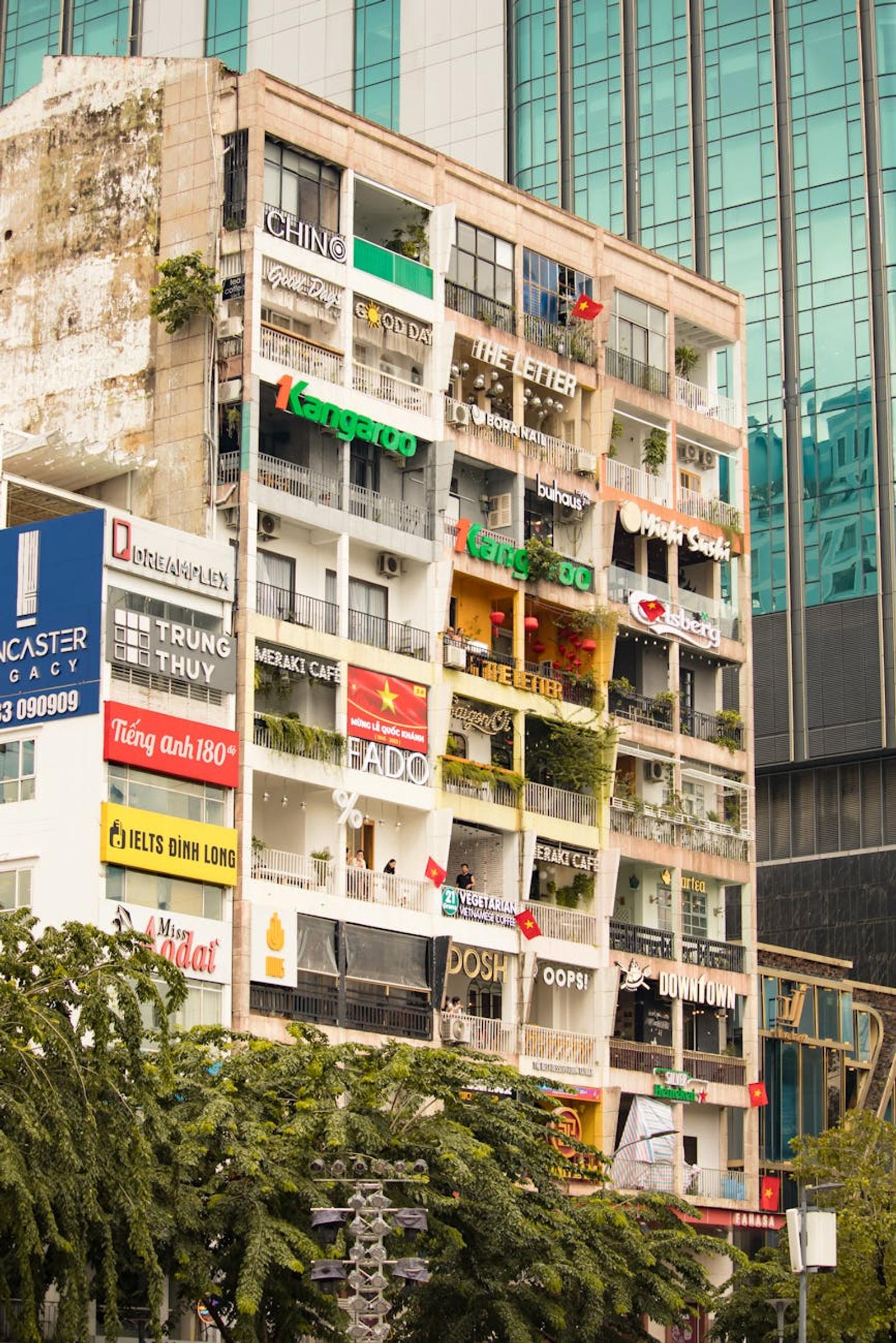 Aging building facade covered in overlapping shop and cafe signage