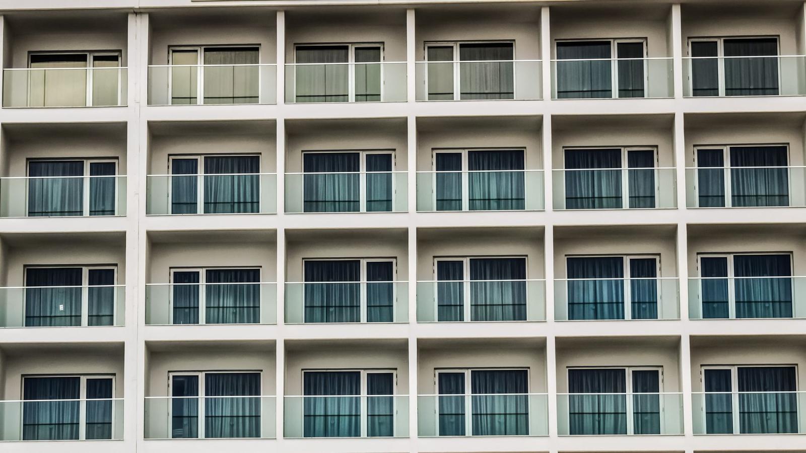 A repeating grid of curtained balcony windows on a hotel facade
