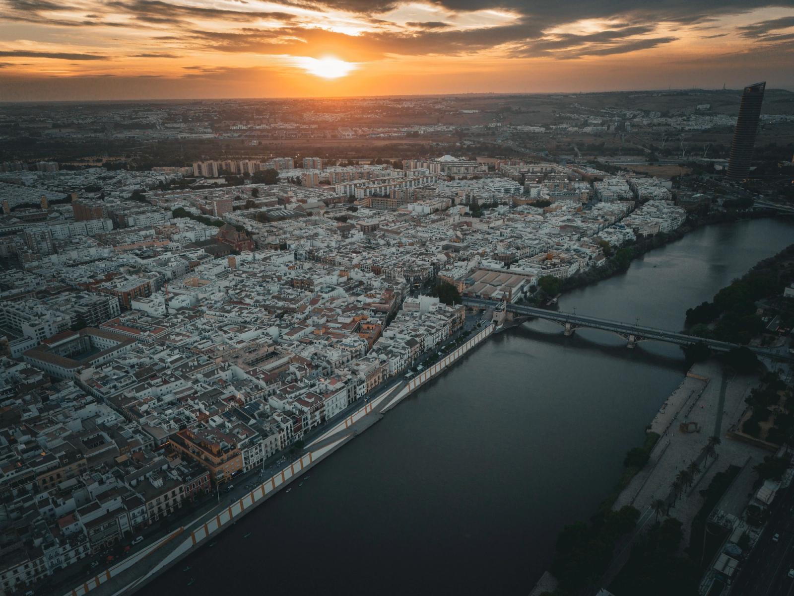 Stunning aerial view of Seville, Spain at sunset showcasing the city's architecture and river