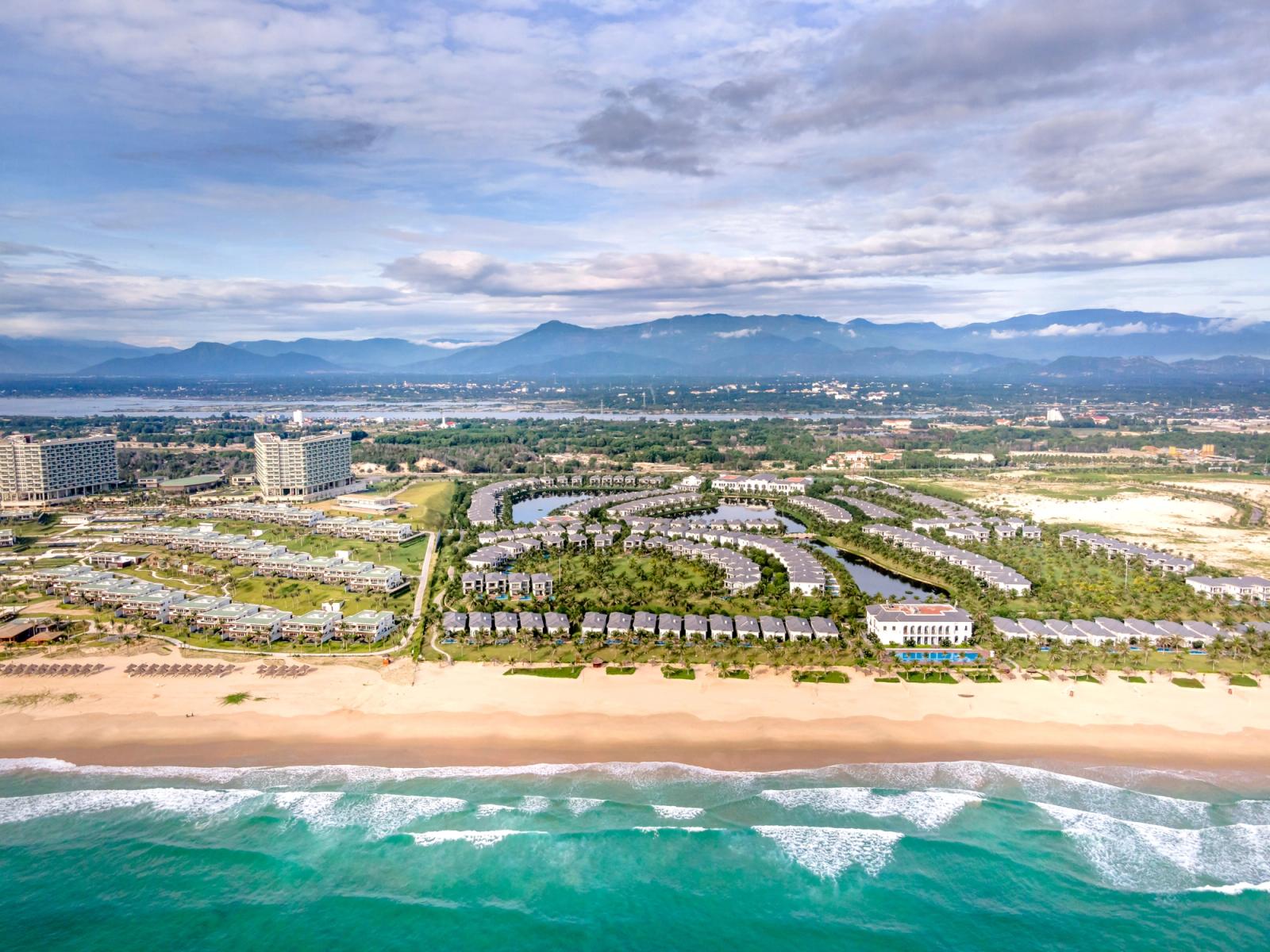 Stunning aerial view of a beachside resort with palm trees and modern architecture