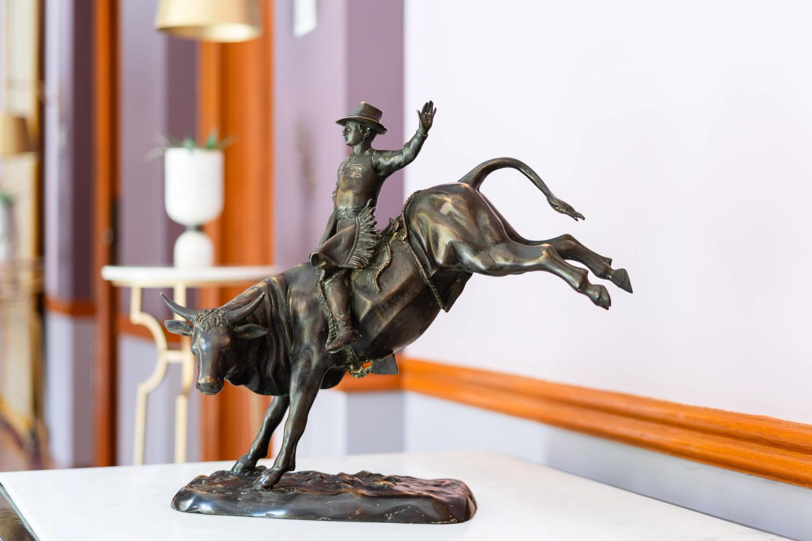 Bronze sculpture of cowboy riding a bucking bull displayed in a luxurious Rajasthan hotel