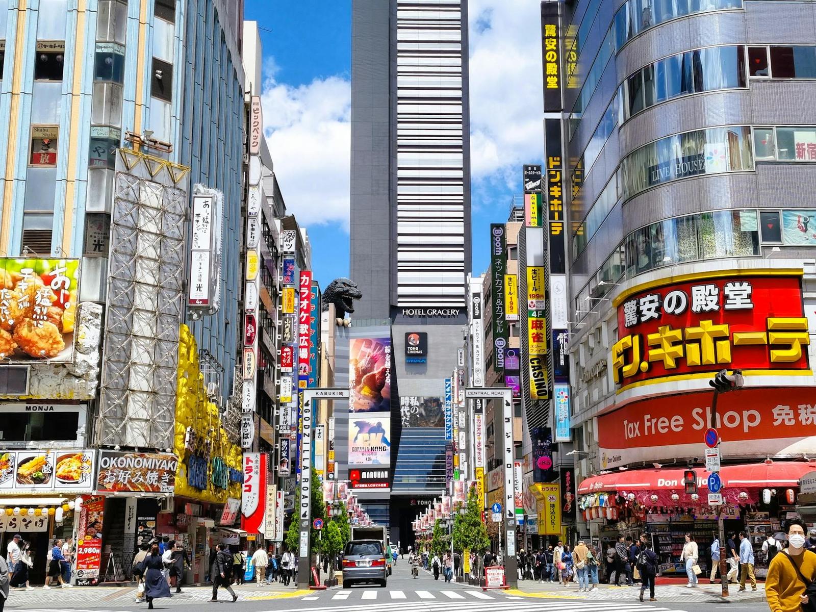 A busy shopping street lined with neon signs and crowds of pedestrians