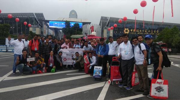 Group of people smiling and posing on a road