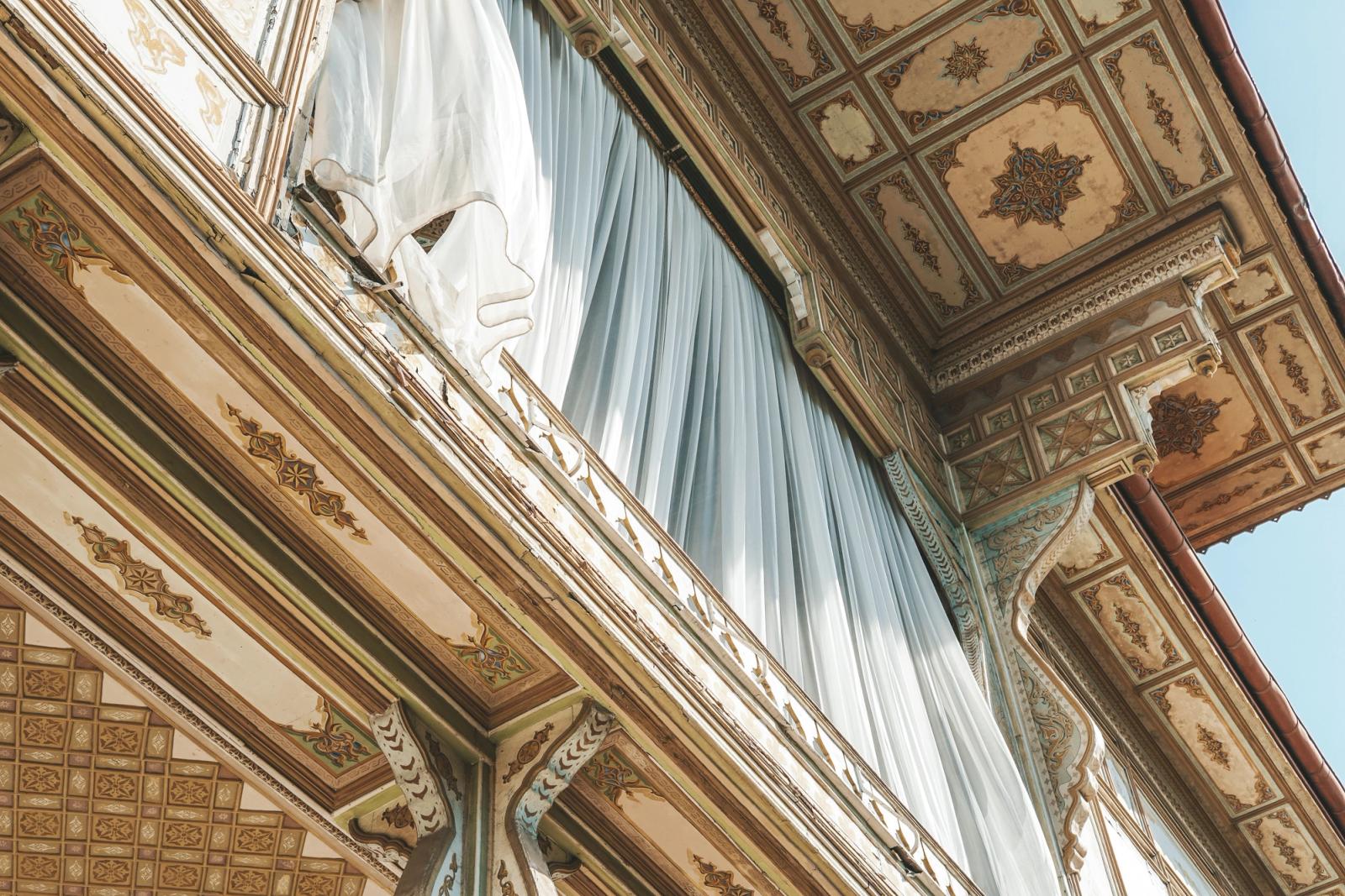 Detailed view of ornate Ottoman architecture featuring intricate patterns and a flowing curtain in Istanbul