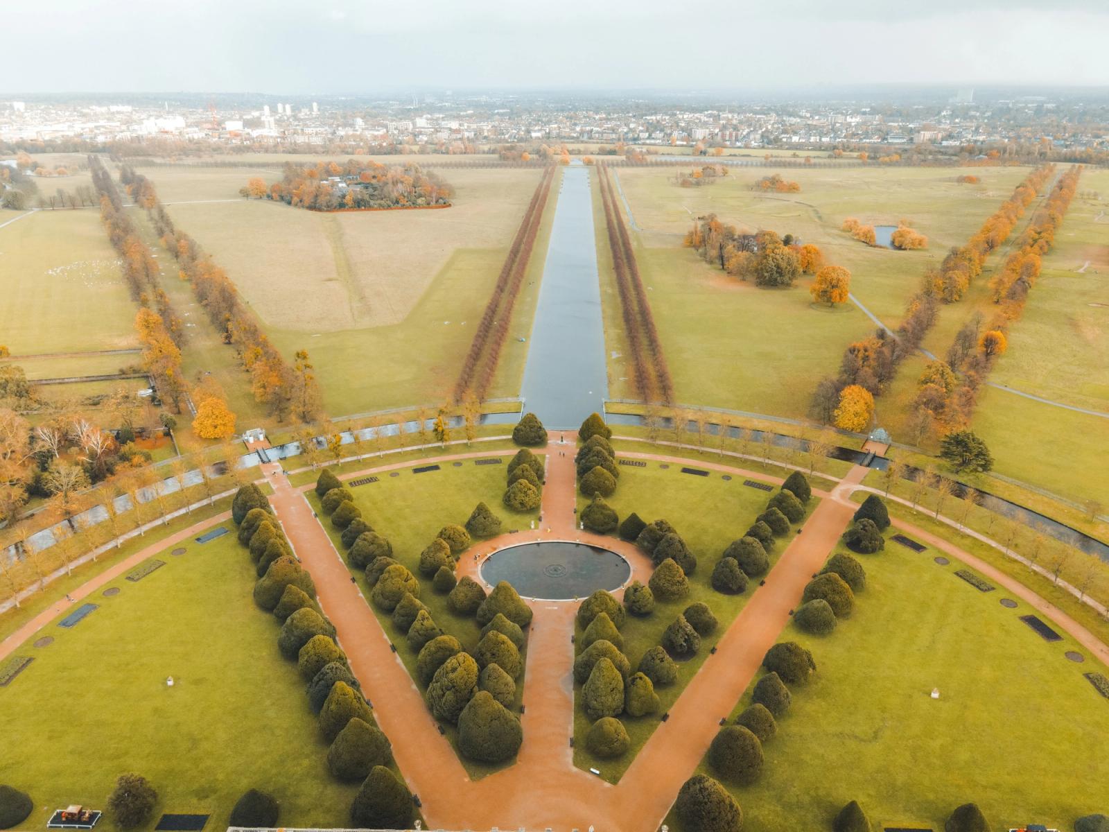 Picturesque aerial view of well groomed gardens and fountains of ancient historic Hampton Court Palace located in London