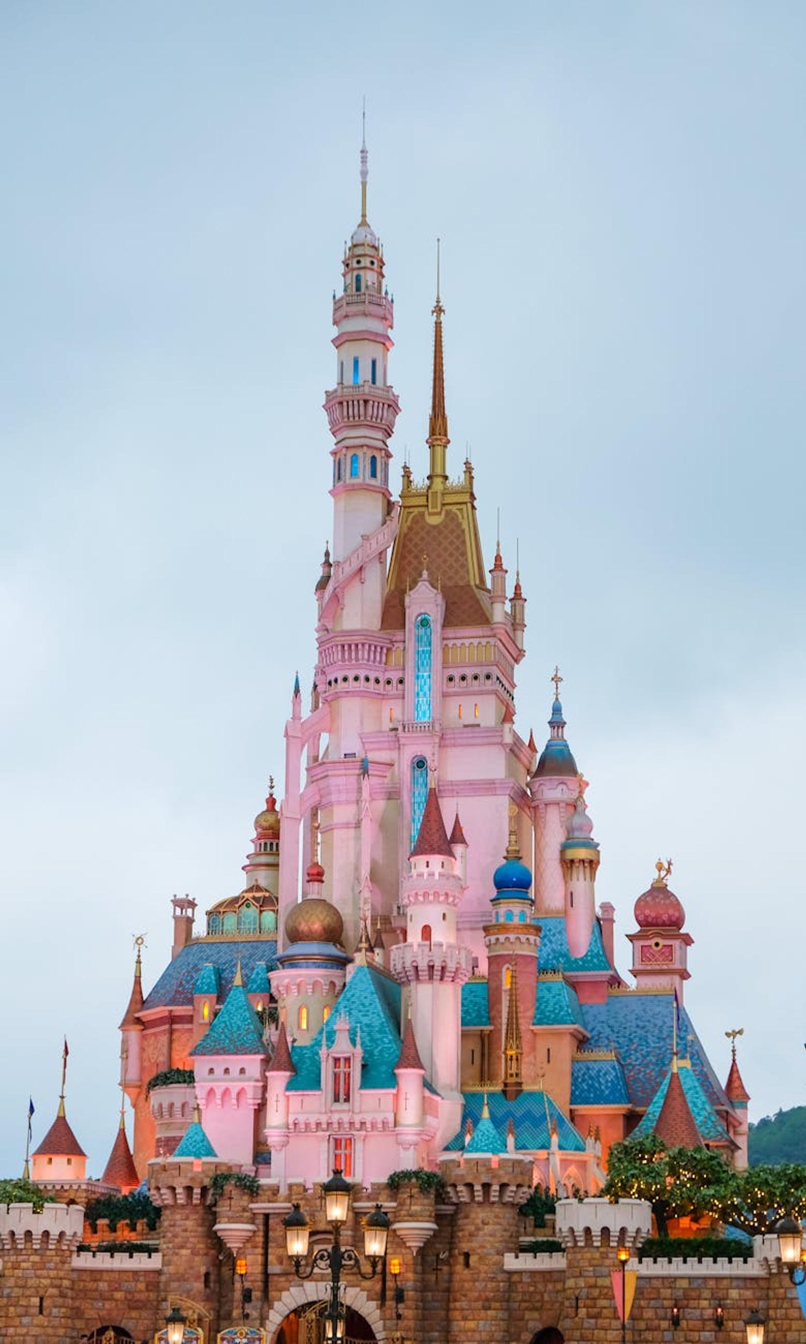 Pink and blue fairytale castle with spires against a dusky sky