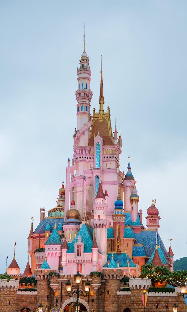 Pink and blue fairytale castle with spires against a dusky sky