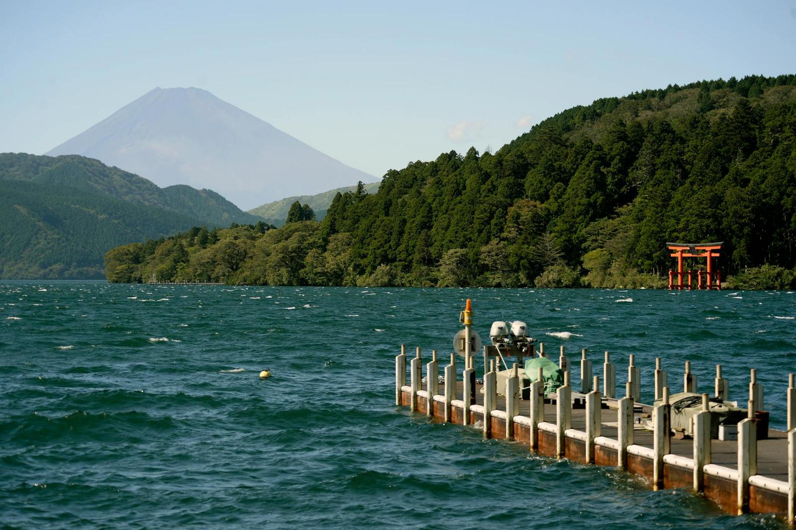 Beautiful landscape of Mount Fuji by Lake Ashi with a serene pier and torii gate