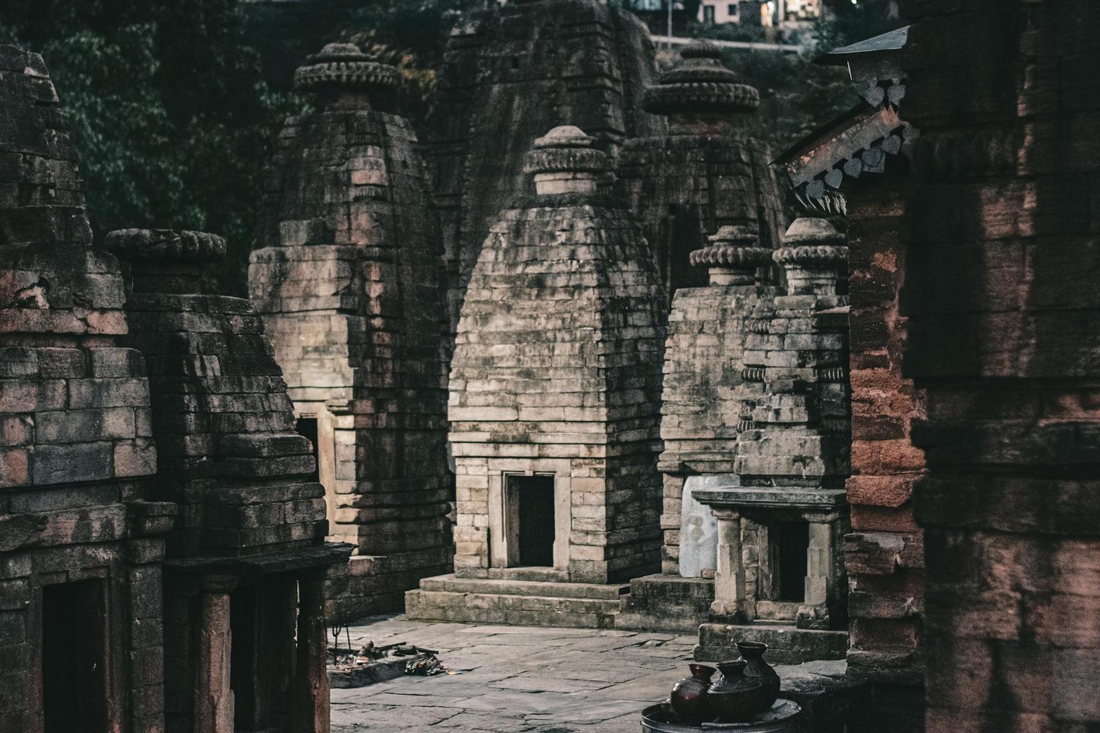 Weathered stone temple towers clustered in a dim courtyard