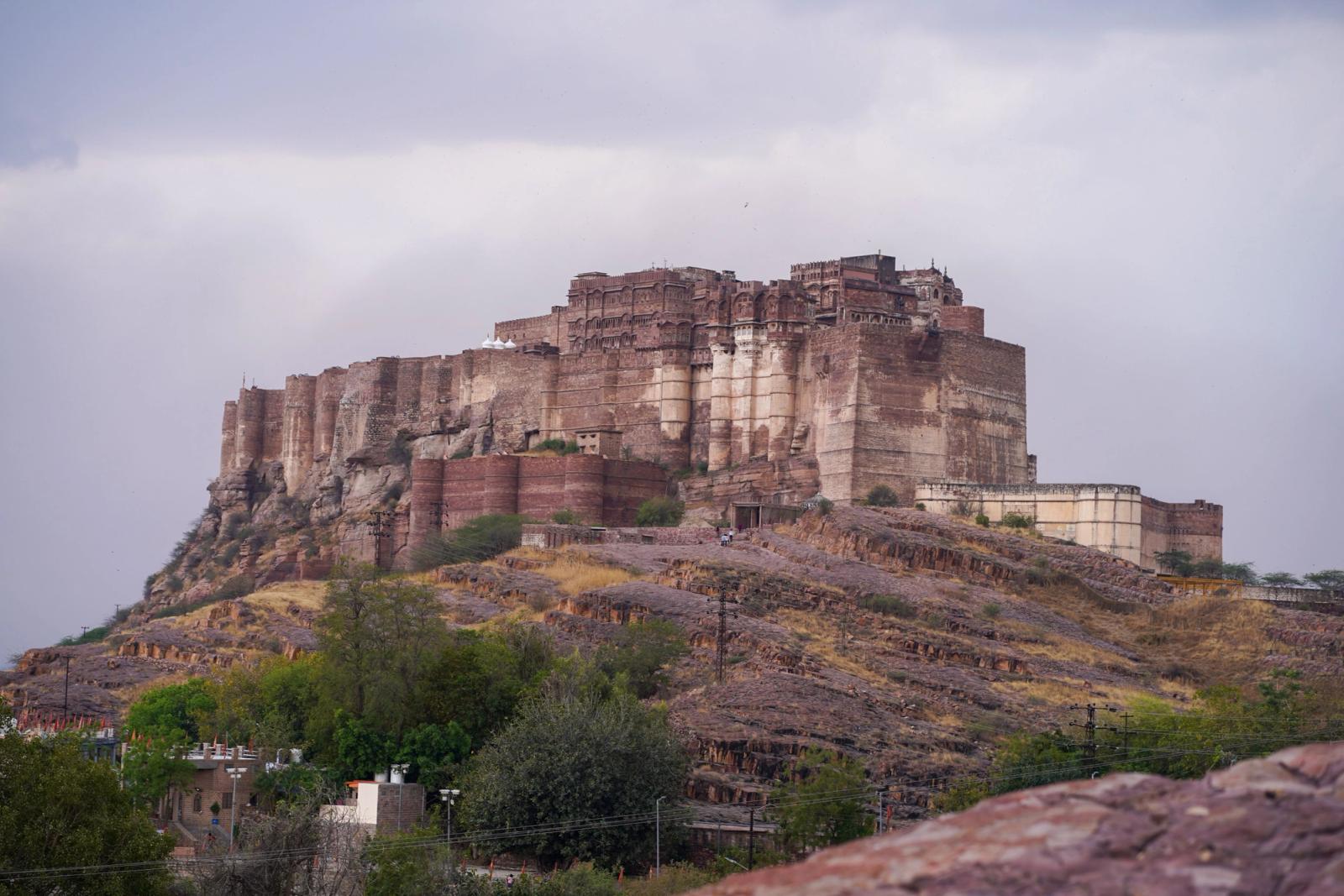 Scenic view of the iconic Mehrangarh Fort in Jodhpur, Rajasthan, showcasing historical architecture against a cloudy sky