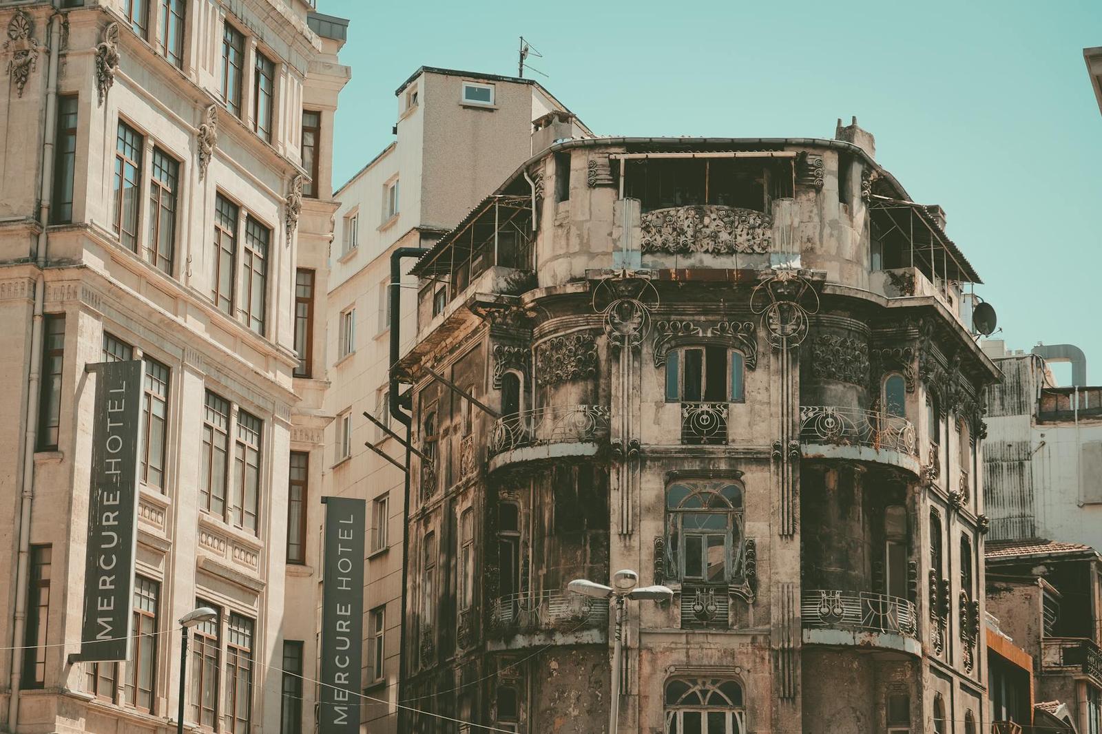 Weathered corner hotel building with an ornate facade and rooftop terrace