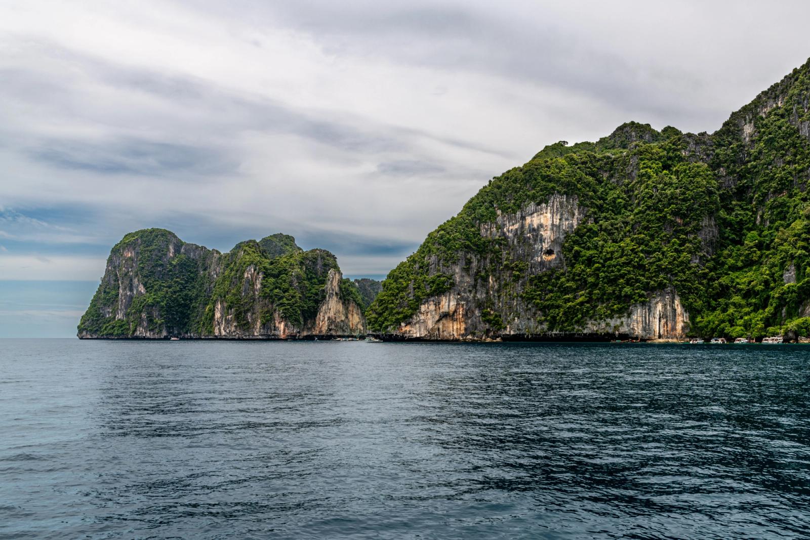 Explore the stunning limestone cliffs and dense greenery of Phuket's picturesque coastline in Thailand