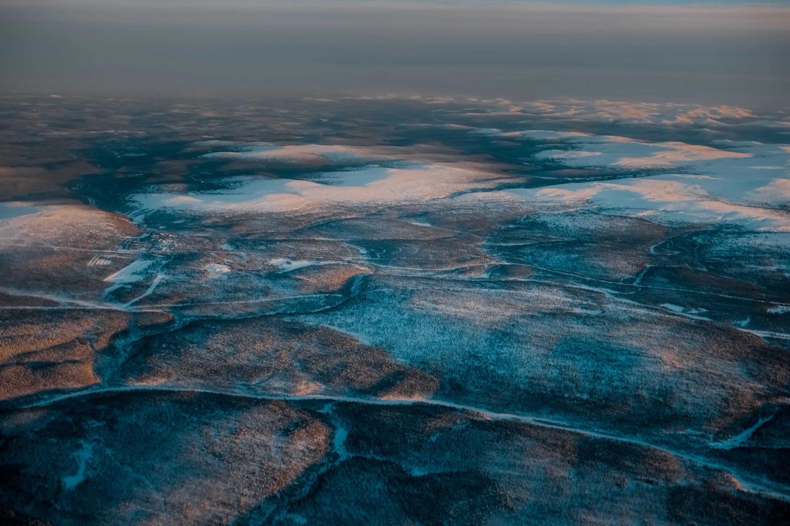 Aerial view of snow-covered landscapes in Finland during winter's twilight
