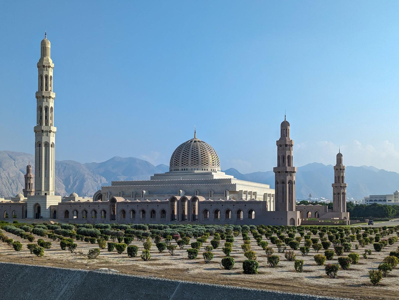 Sultan Qaboos Grand Mosque with its striking minarets against a clear blue sky in Muscat, Oman