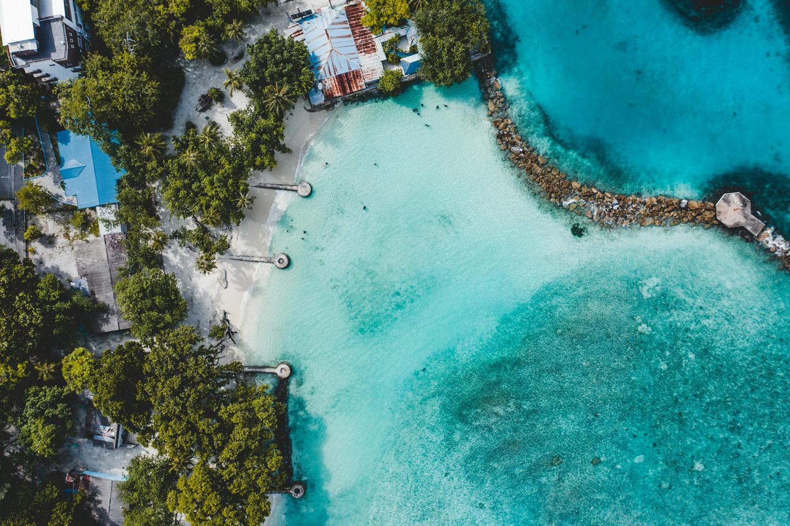Aerial view of a resort beach bordered by reef and jetties