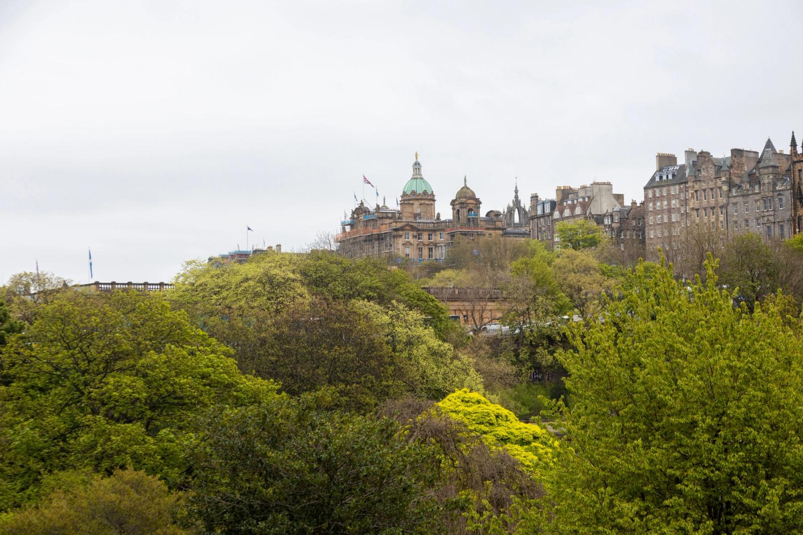 Beautiful view of Edinburgh's architecture surrounded by lush greenery on a cloudy day