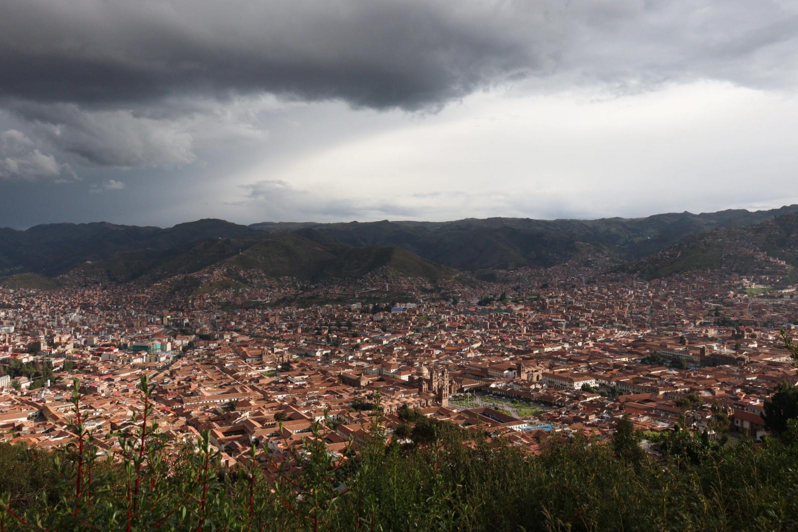 Panoramic shot of Cusco, Peru under dramatic skies, showcasing the city's vast expanse and beautiful architecture