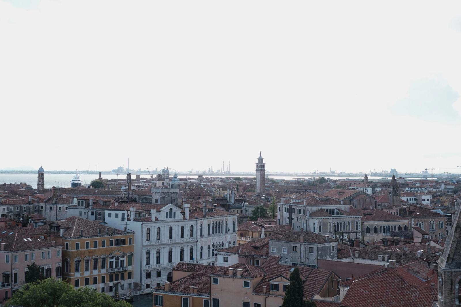 Stunning aerial view of Venice showcasing historic buildings and a vibrant cityscape under a cloudy sky
