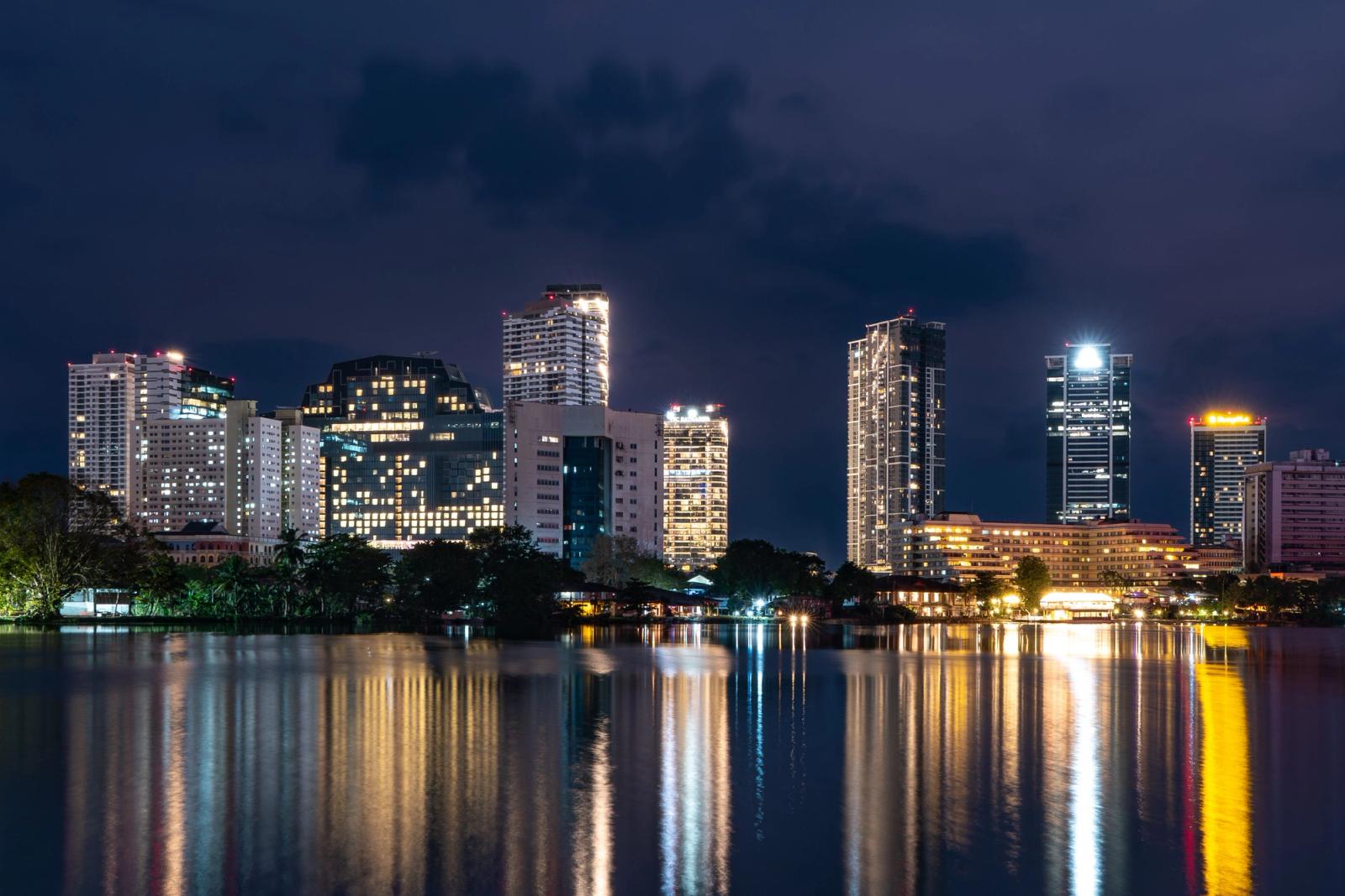 Stunning night view of Colombo skyline with reflections on the water, showcasing modern architecture in Sri Lanka
