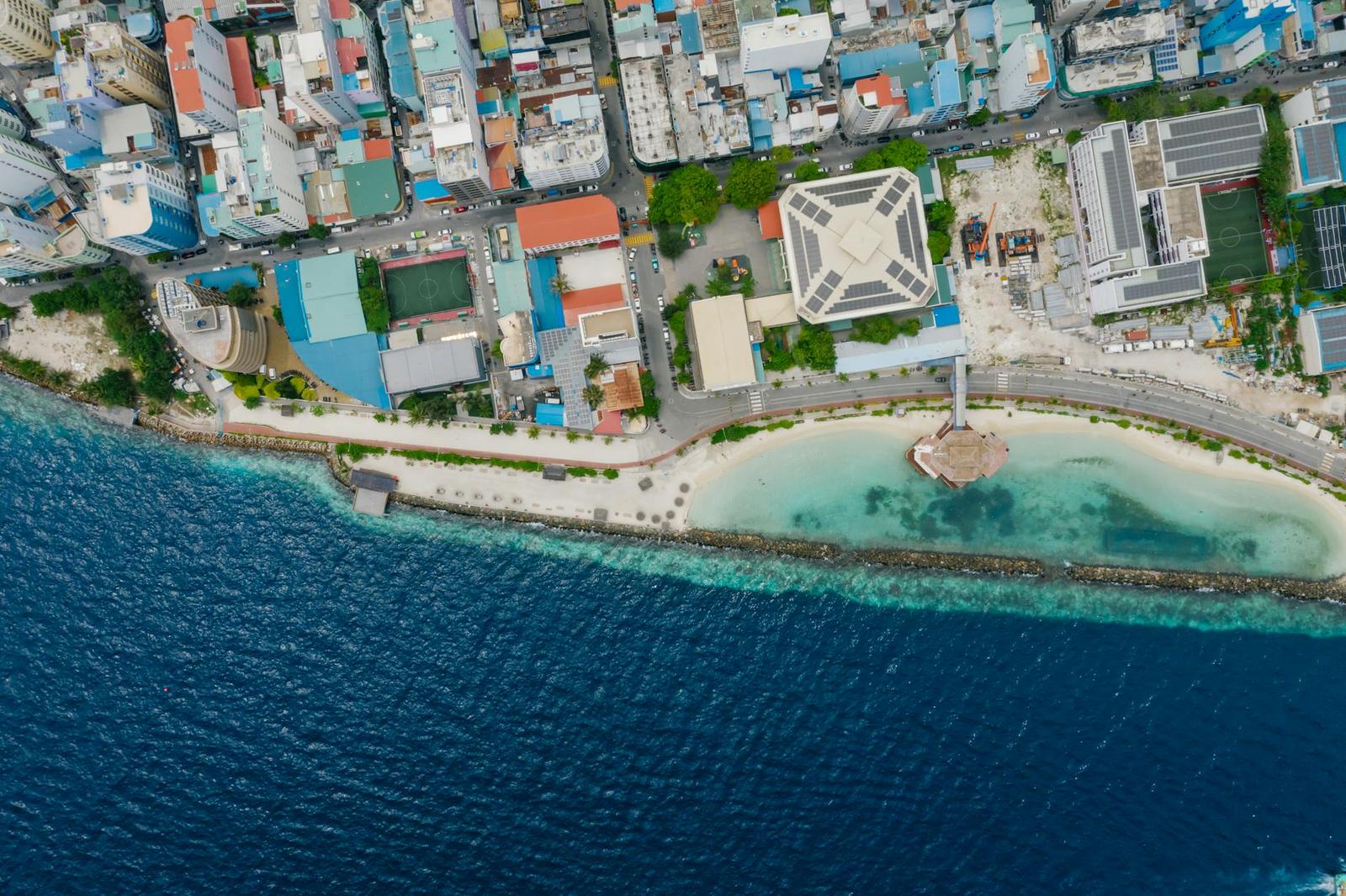 Aerial view of a coastal town curving around a shallow reef lagoon