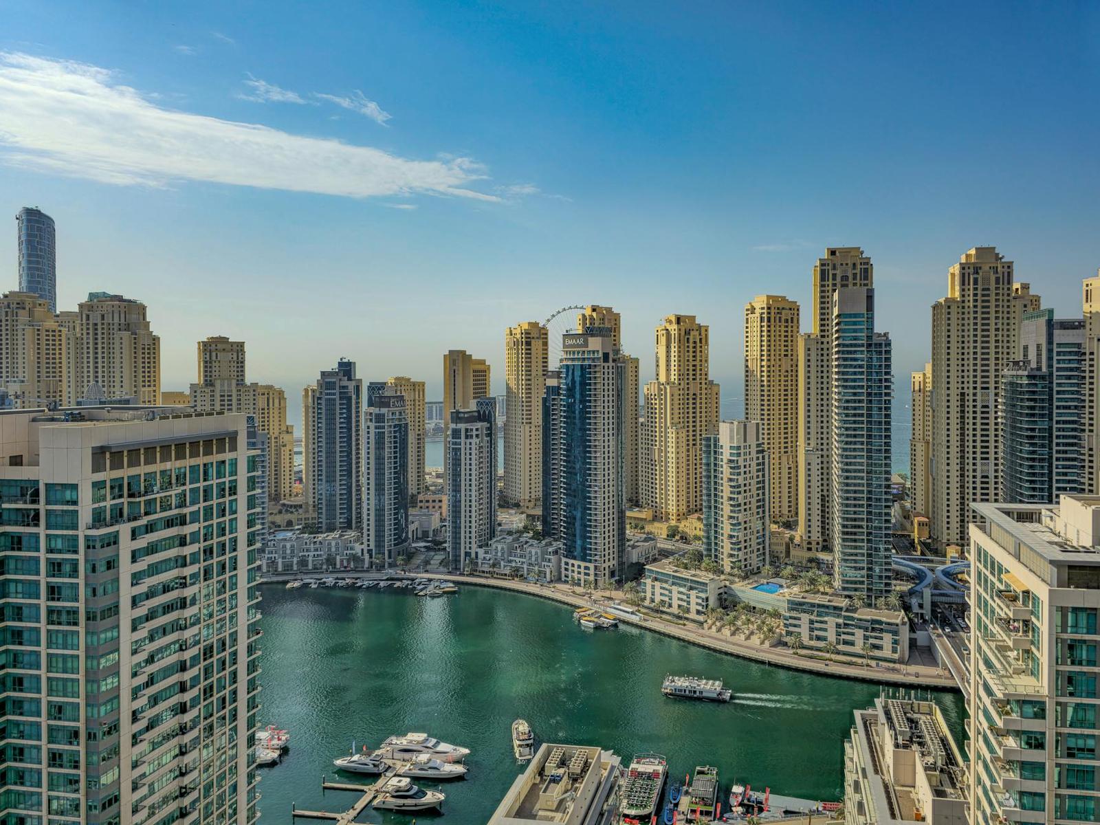 A dense marina of high-rise apartments around a curving turquoise waterway
