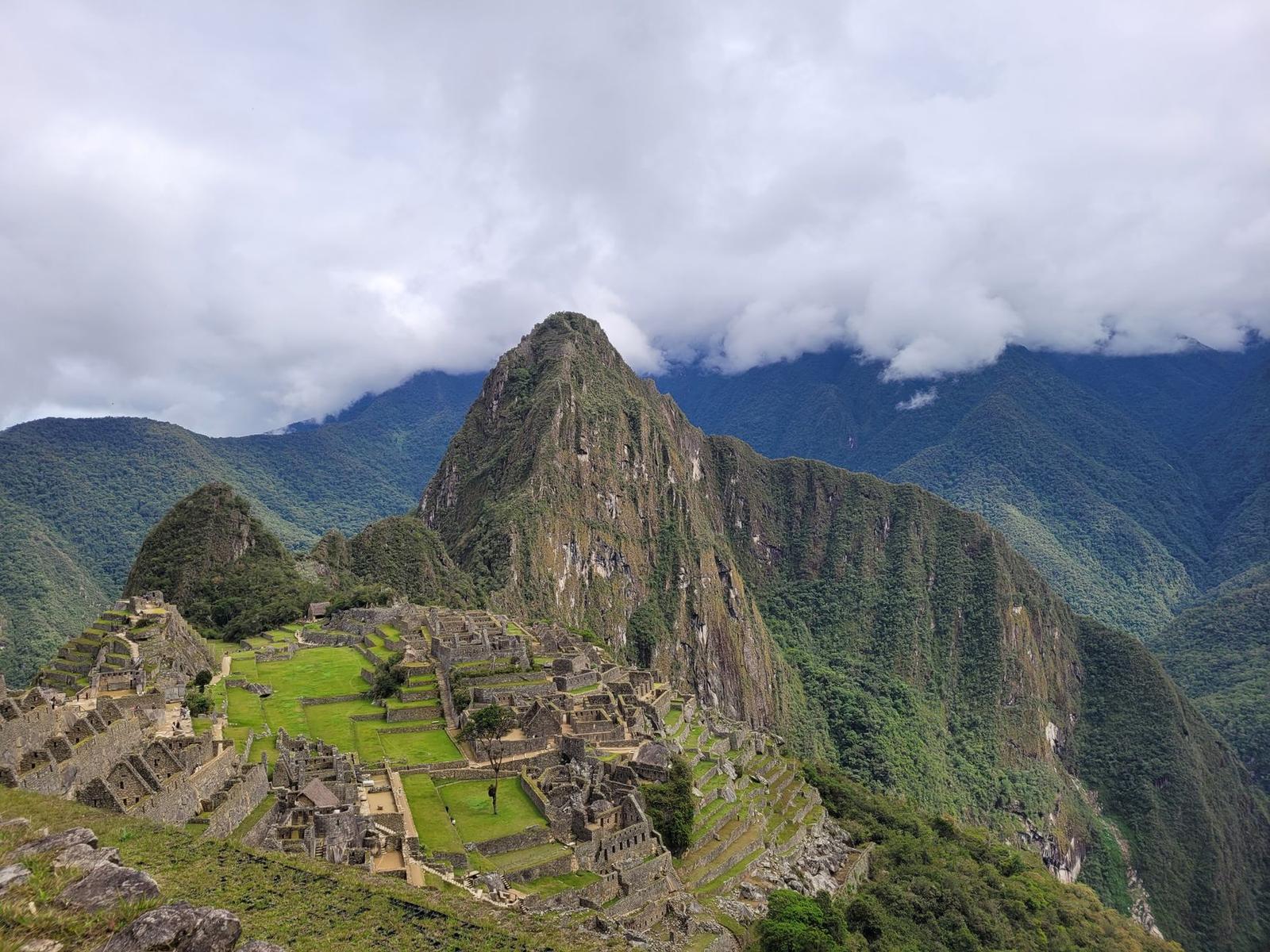 Terraced stone ruins on a misty mountaintop above dense jungle