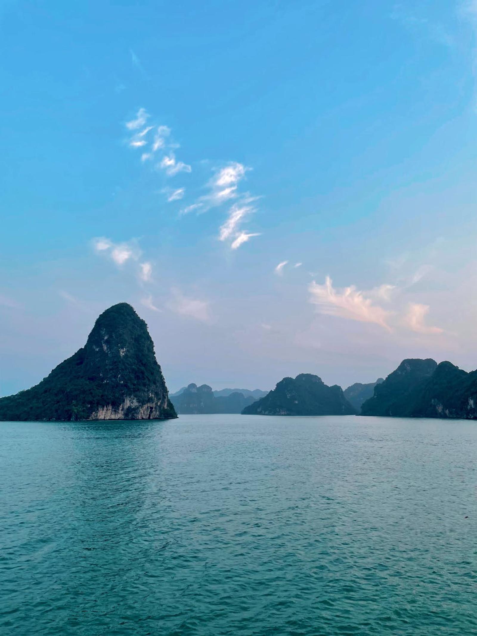 Tranquil sunset view of Lan Ha Bay's limestone karsts and calm waters in Vietnam