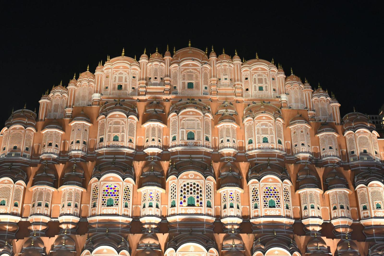 Hawa Mahal's honeycombed facade glowing warm against the night sky