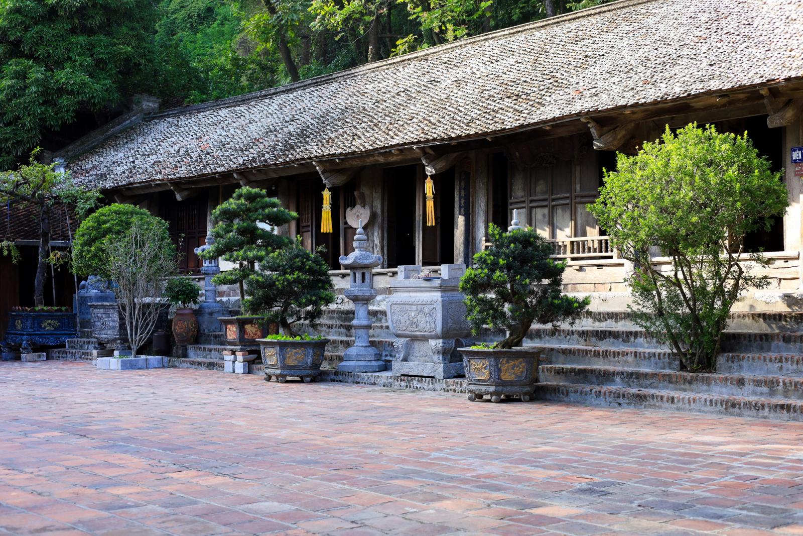 Historic temple courtyard in Hanoi, showcasing Vietnamese architecture and lush greenery