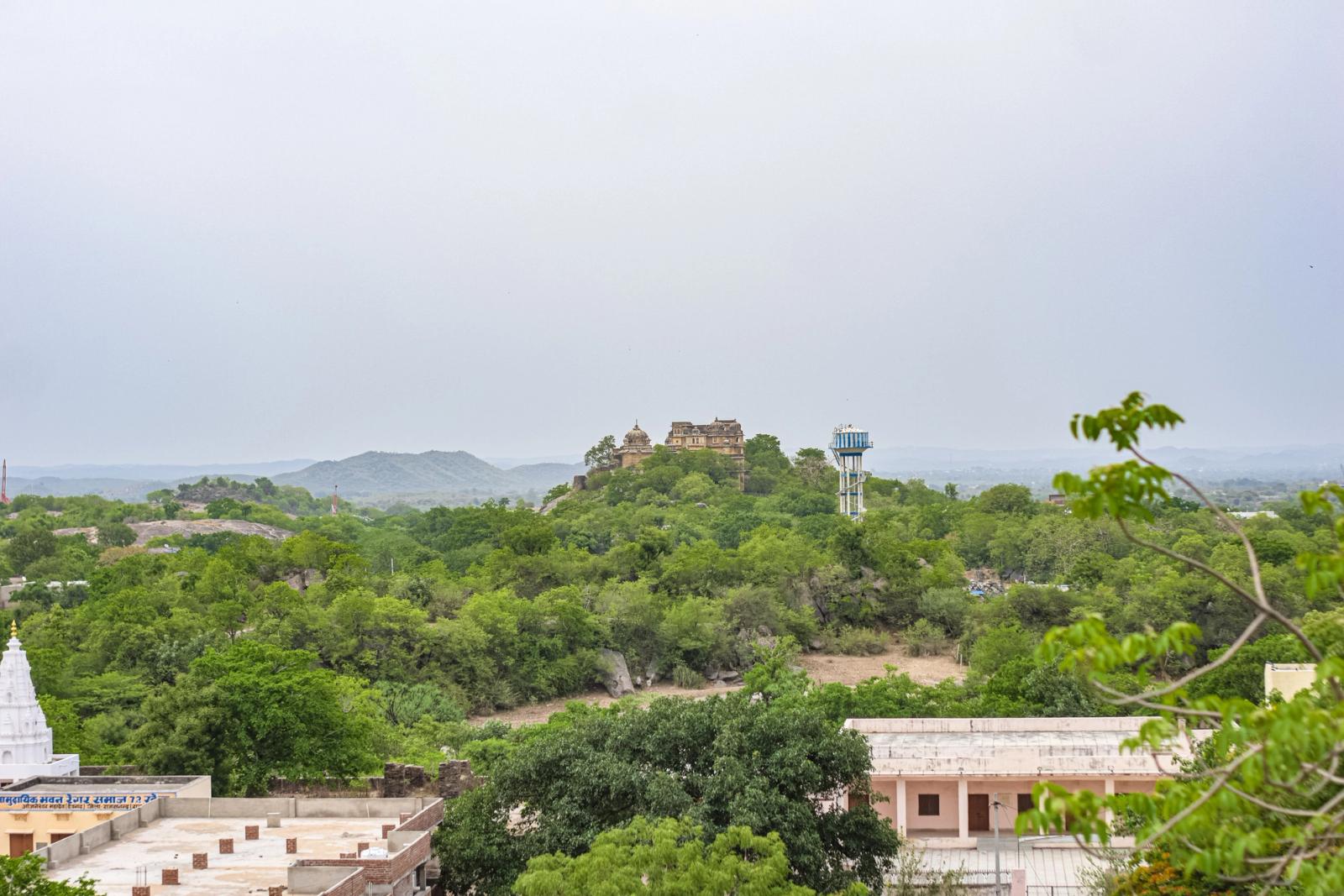Aerial view of a hilltop fort surrounded by lush greenery, capturing serene landscapes