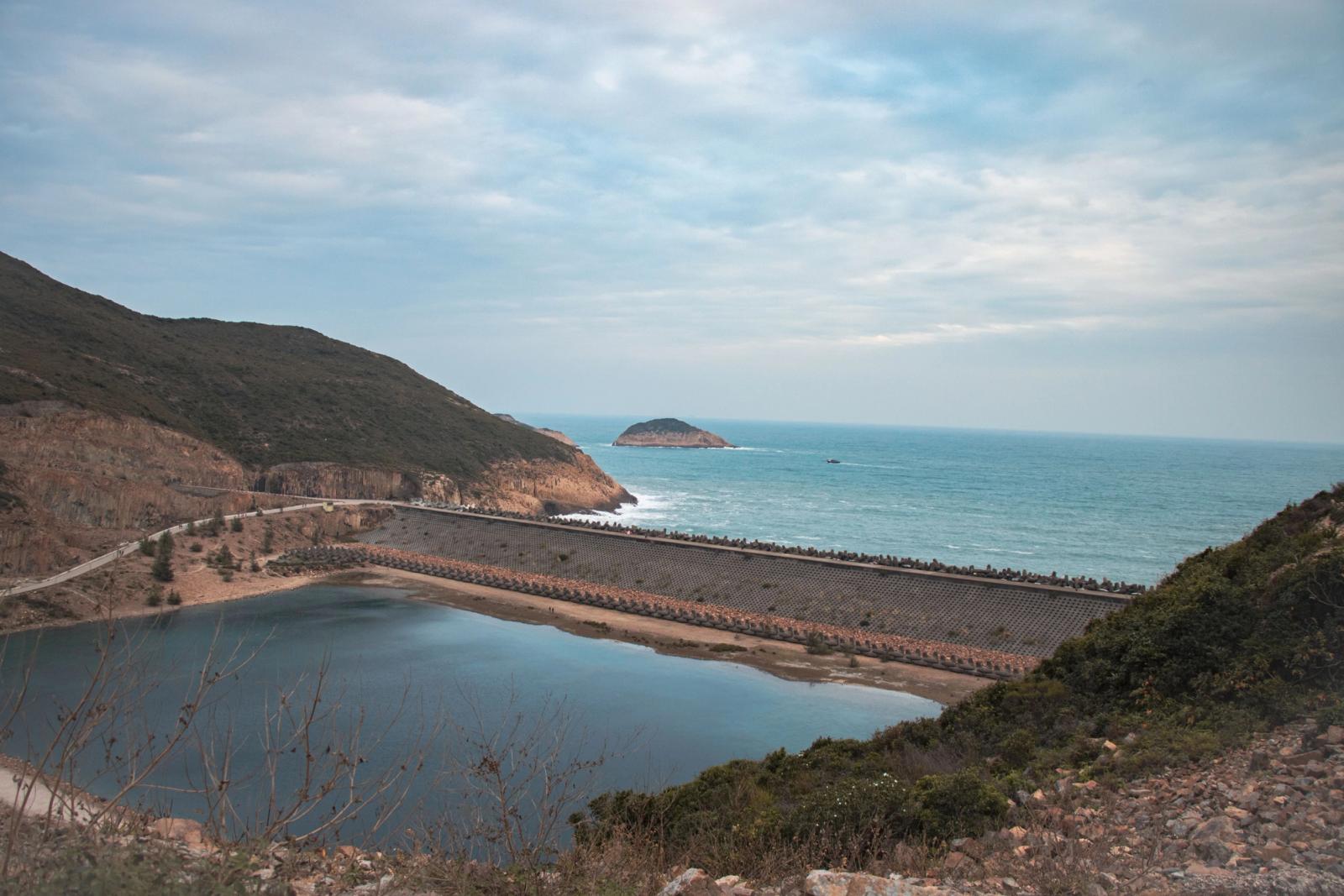 Scenic view of High Island Reservoir in Hong Kong with mountainous backdrop and sea horizon