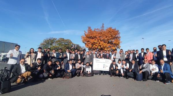 Tibro delegates gather under autumn tree during corporate event.