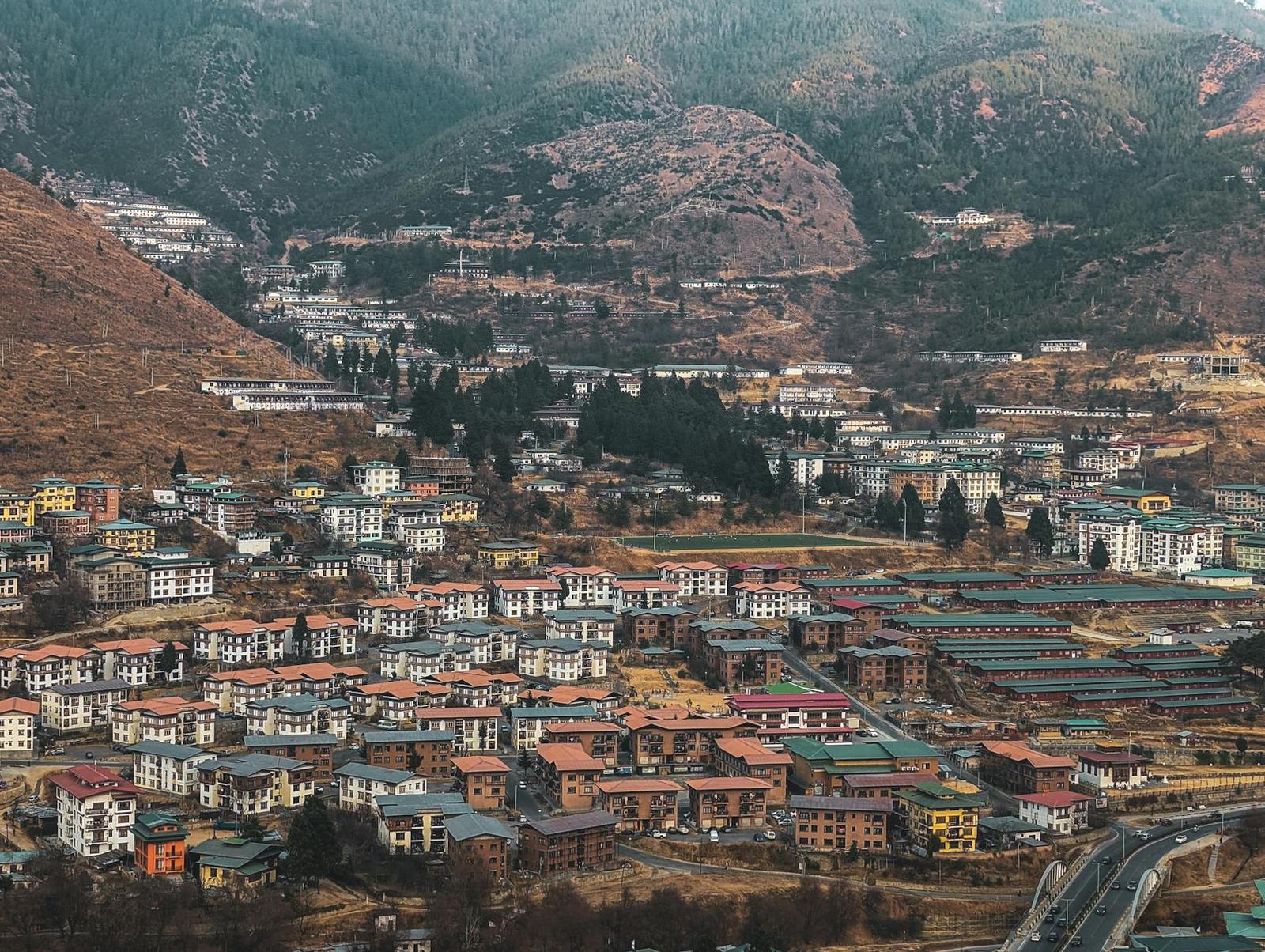 Aerial view of a dense valley town with colourful rooftops among the hills