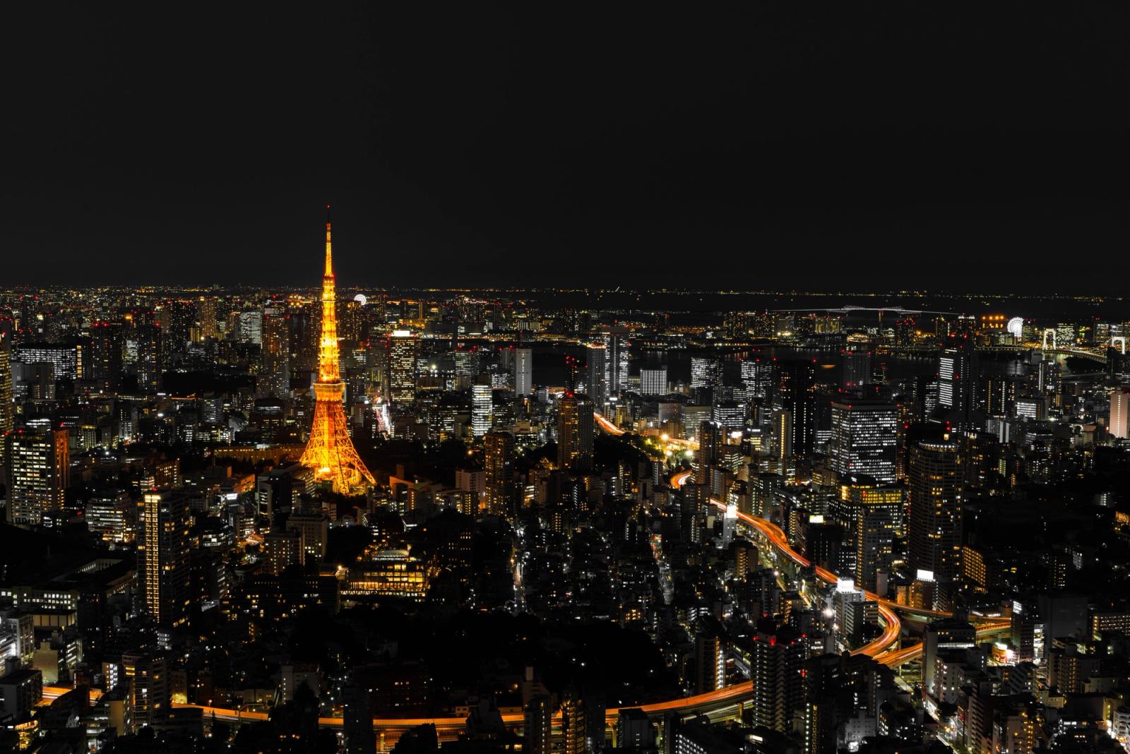 A breathtaking view of Tokyo's night skyline featuring the illuminated Tokyo Tower prominently amidst the city's high-rises
