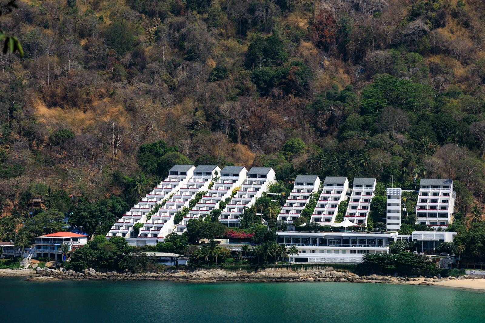 Aerial view of a terraced hillside resort above a rocky shoreline