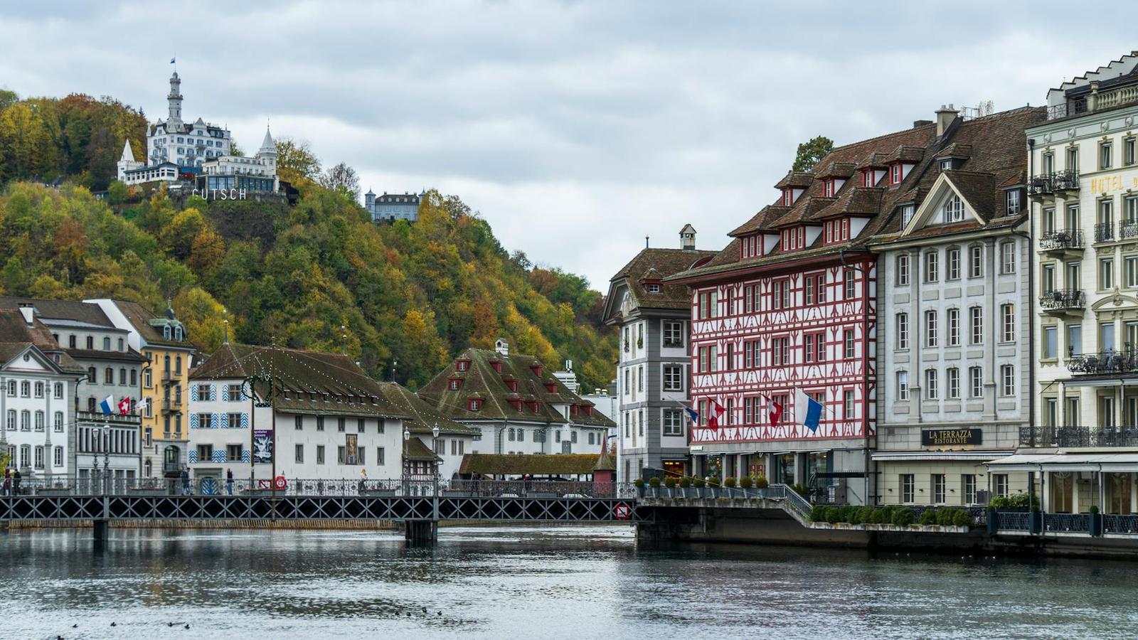 A scenic view of Chapel Bridge and historic architecture along the waterfront in Lucerne, Switzerland