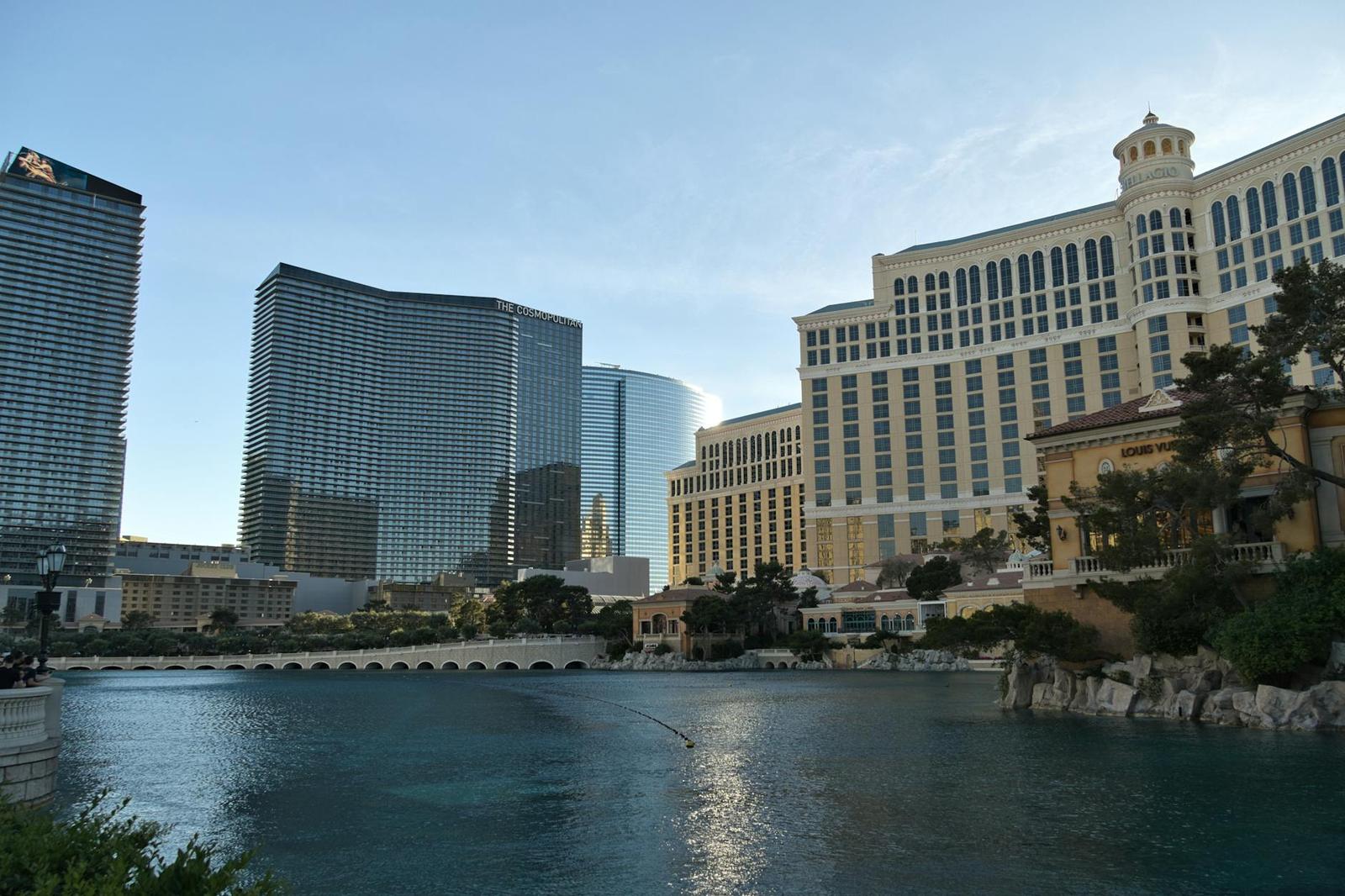 A lakeside view of grand hotel towers and a domed resort at dusk