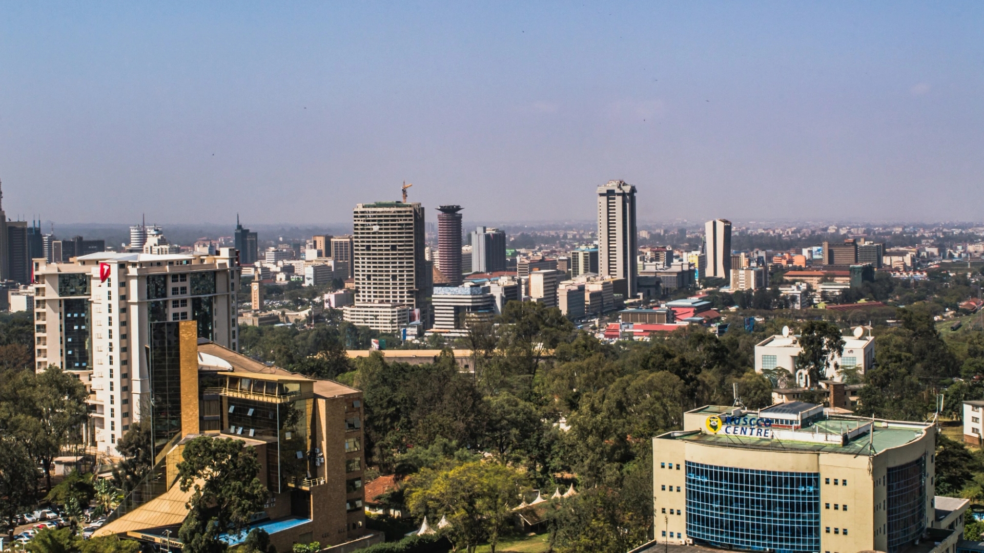 A city skyline of towers and low-rise buildings under a clear sky