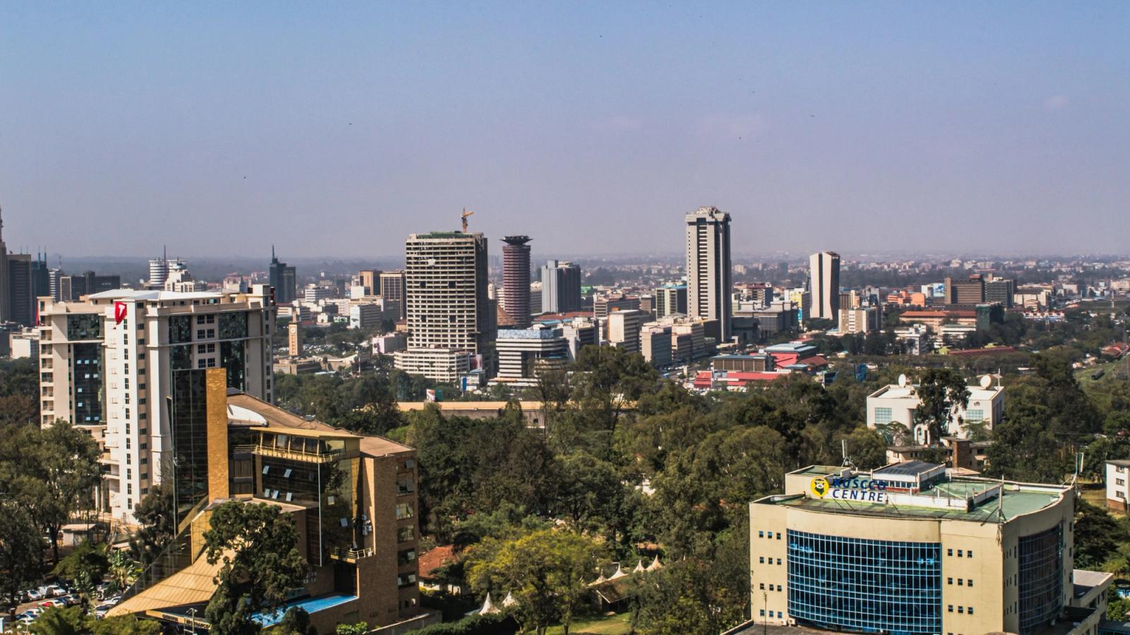 A city skyline of towers and low-rise buildings under a clear sky