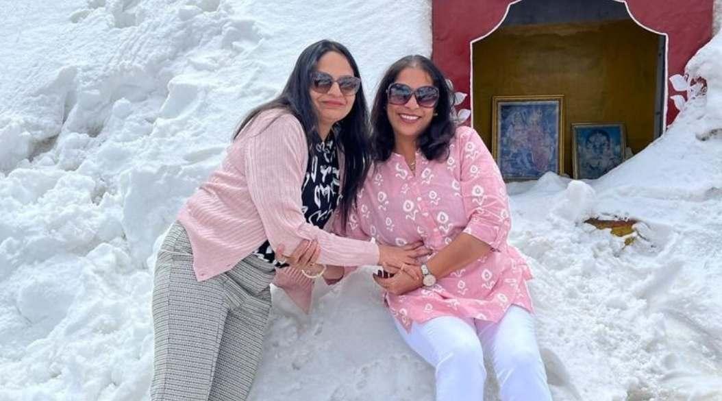 Two girls sitting on the snow