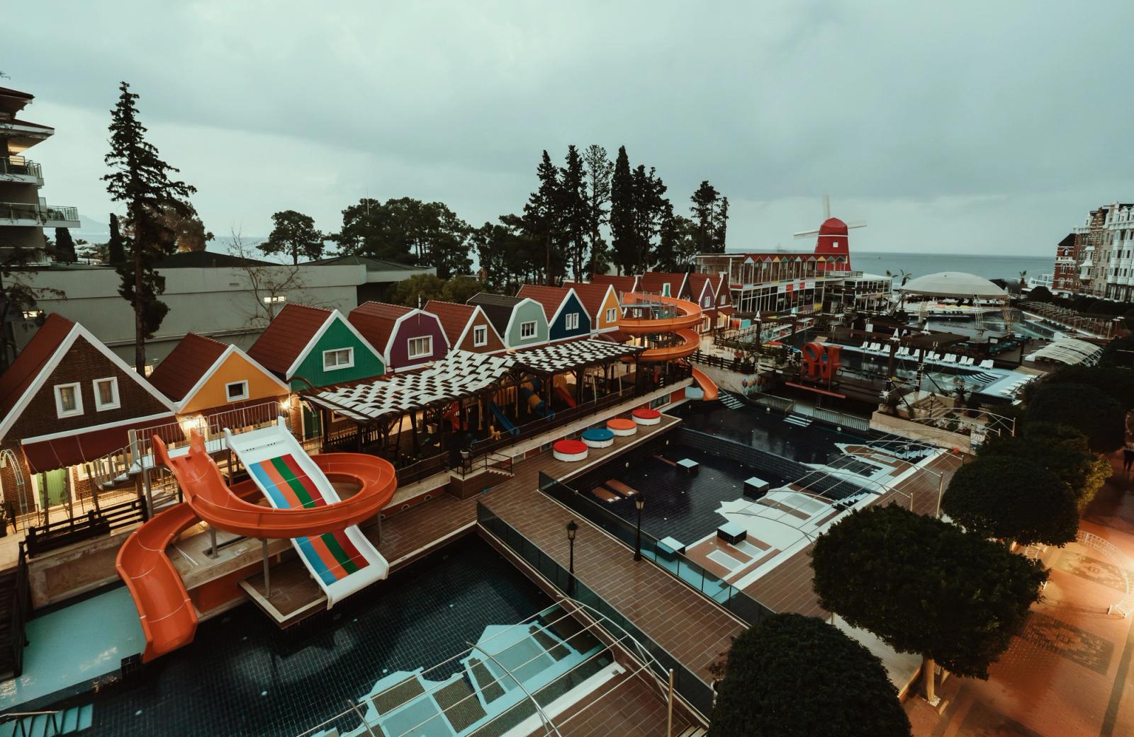 A vibrant resort in Antalya, Türkiye with colorful houses and exciting water slides overlooking the sea