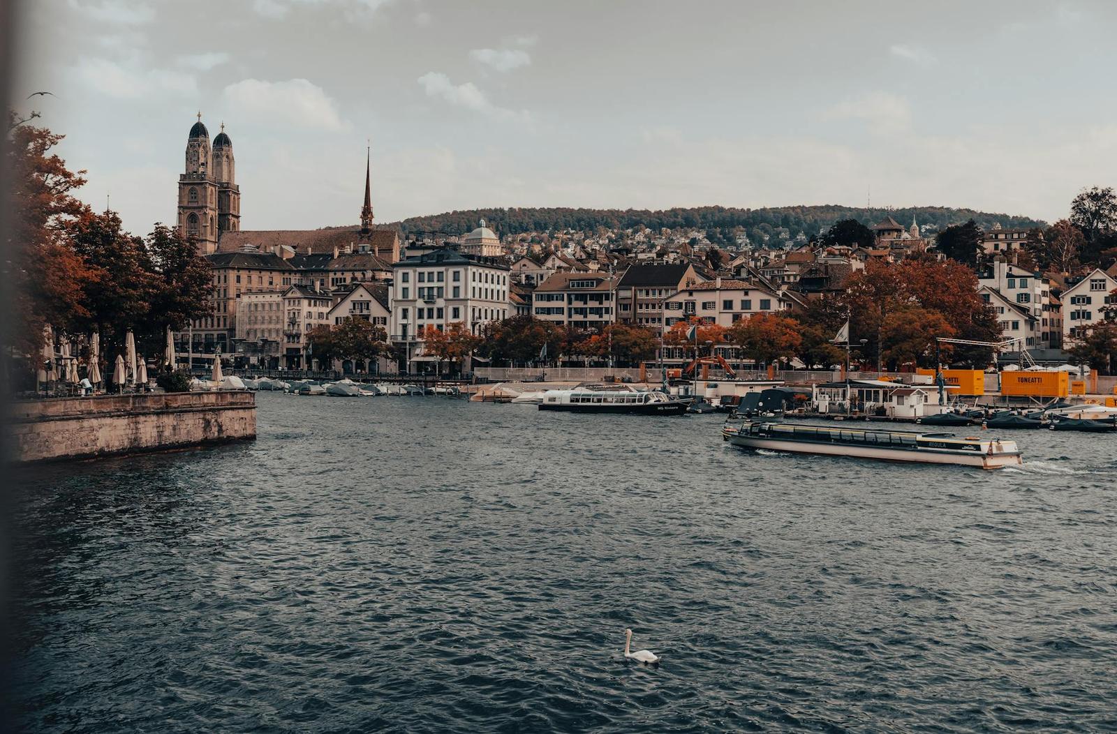 River city skyline with twin church towers and boats on the water