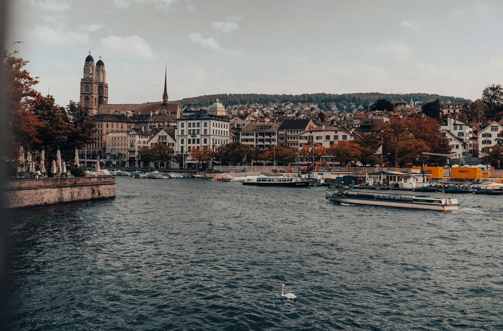 River city skyline with twin church towers and boats on the water